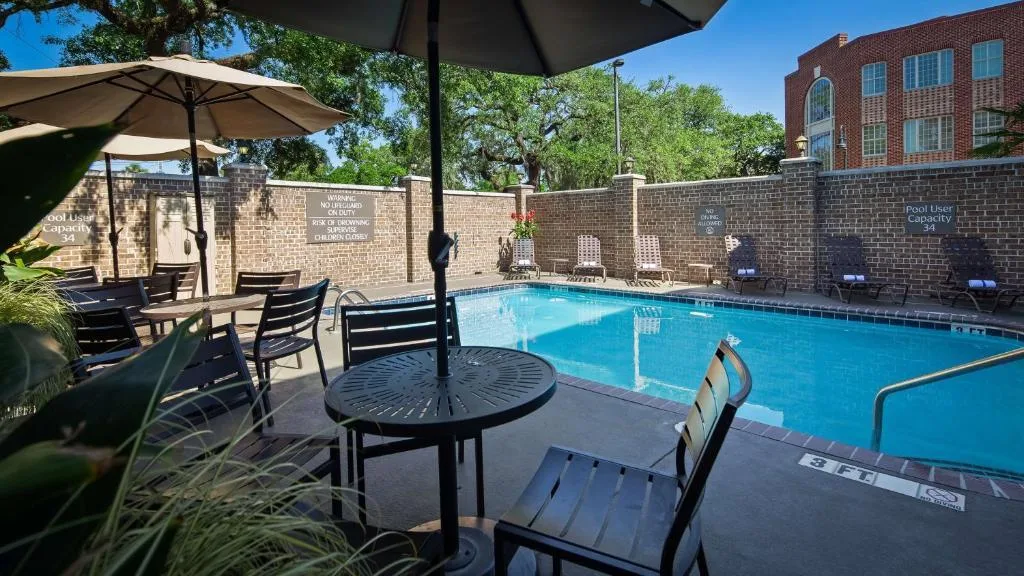 Stoelen en tafels aan het buitenzwembad van het Hotel Best Western Plus Savannah Historic District
