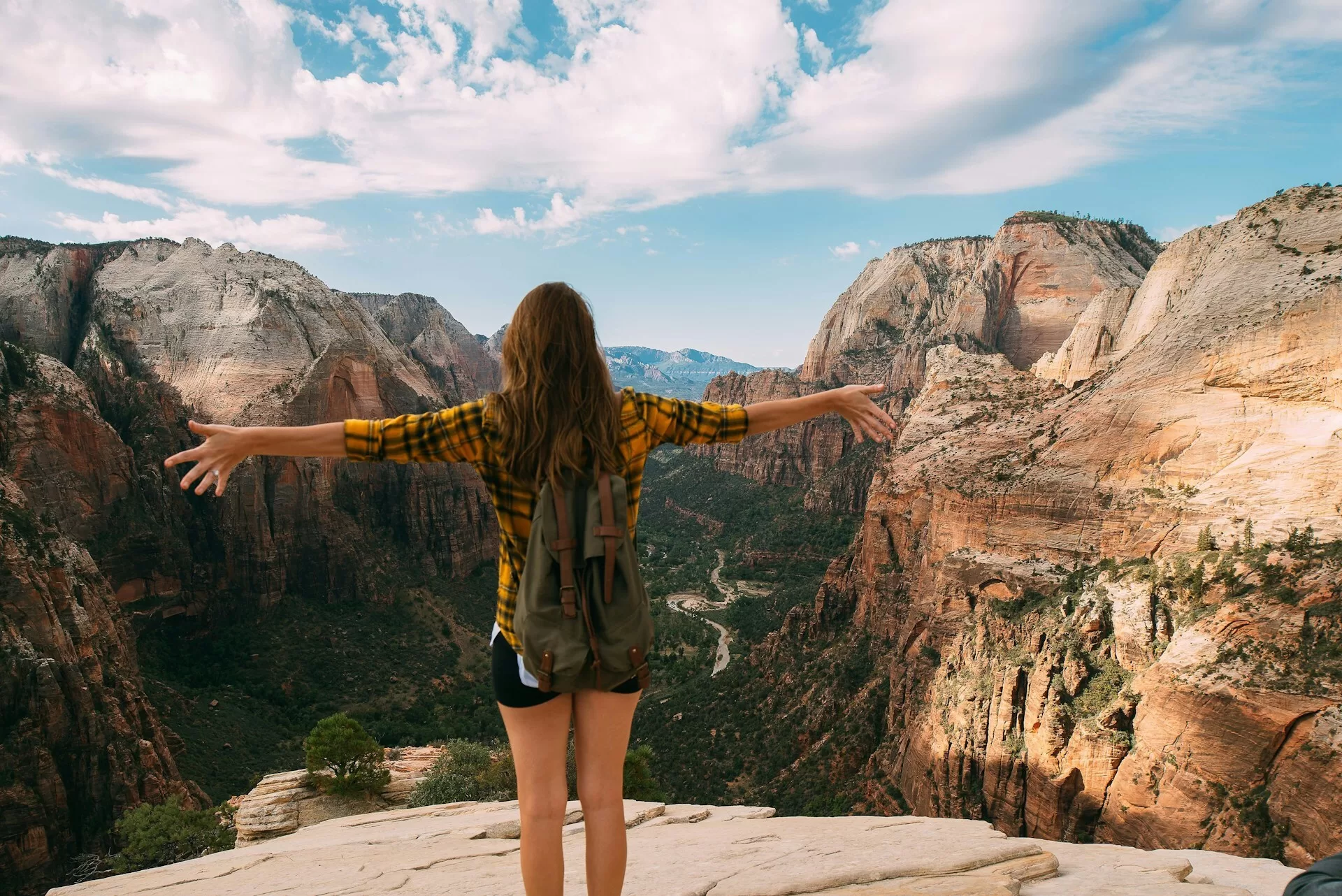 Wandelaarster met uitgestrekte armen op uitzichtpunt in Zion National Park in Utah Amerika