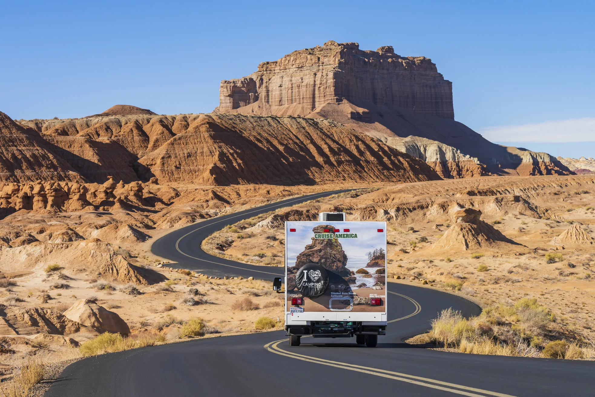 Een Cruise America camper op een weg langs rotsformaties