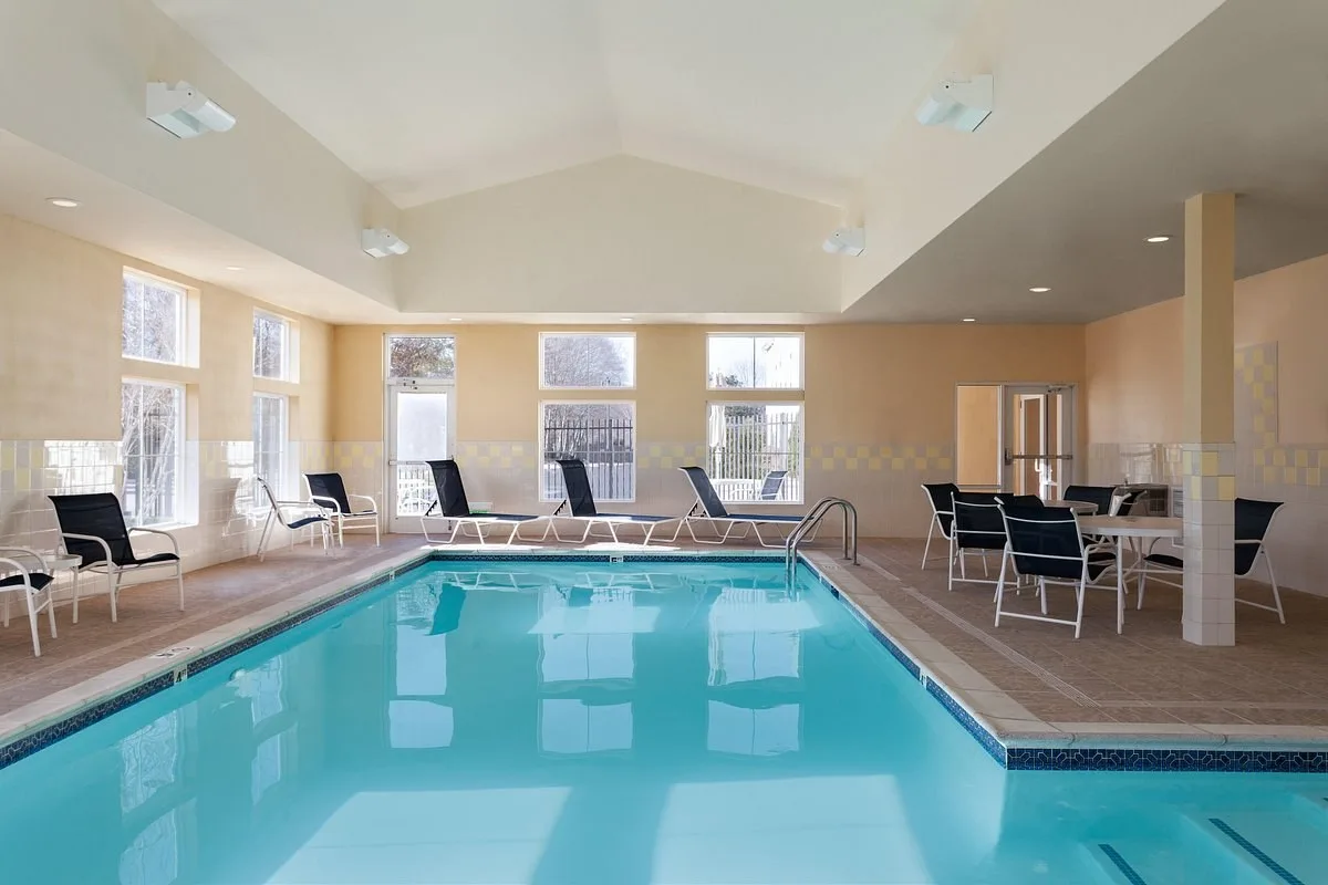 Binnenzwembad met loungestoelen in het Hotel Hampton Inn Suites Mystic