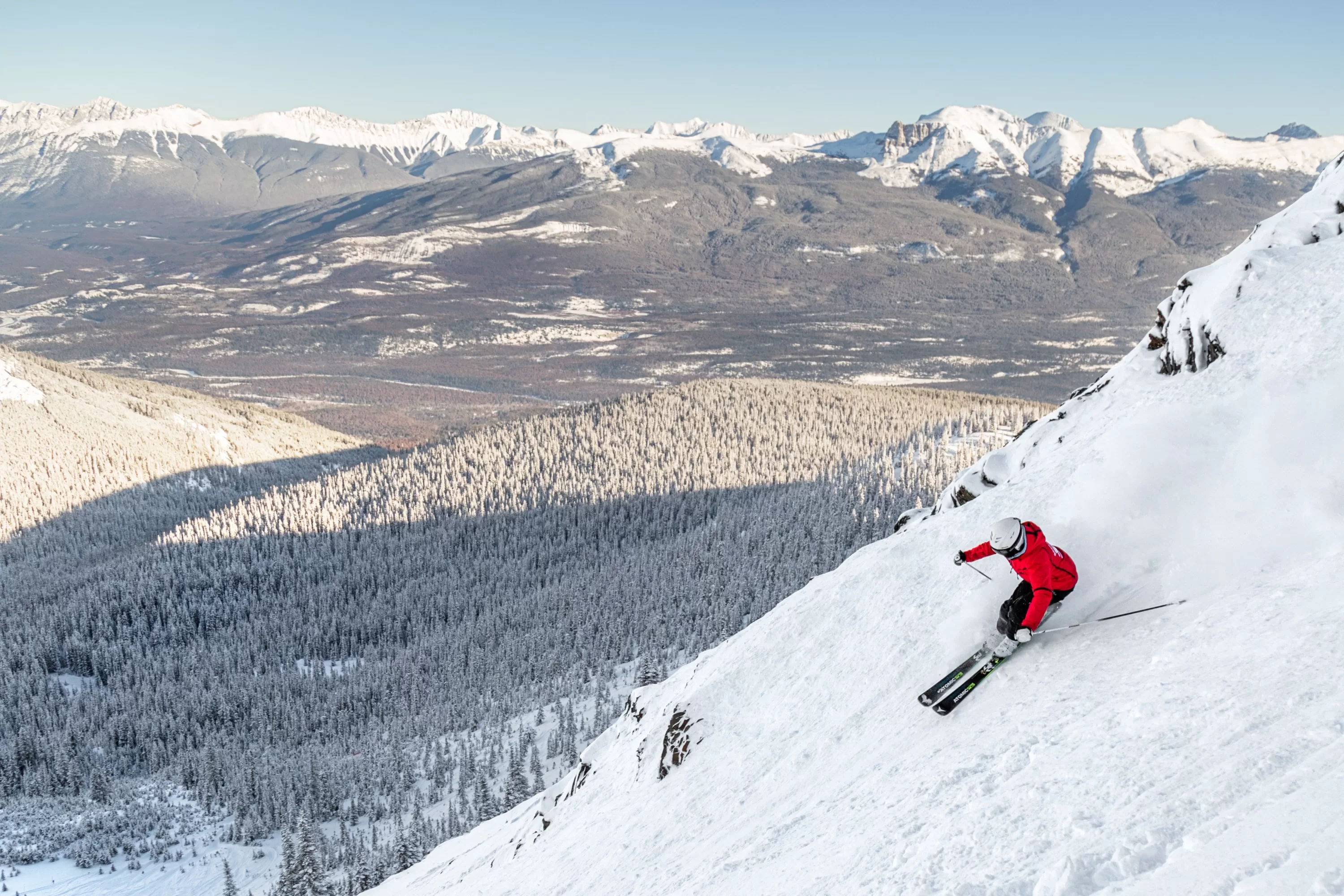 Ervaren skiër afdalend van een steile helling in het skigebied van Jasper Canada