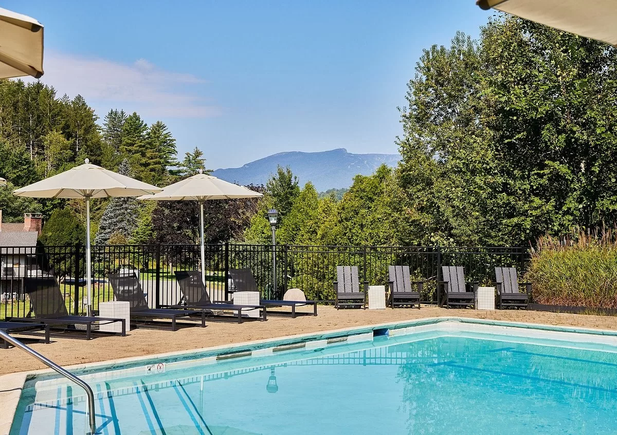 Ligbedjes aan het buitenzwembad van het Hotel Bluebird Cady Hill Lodge met uitzicht over de bergen