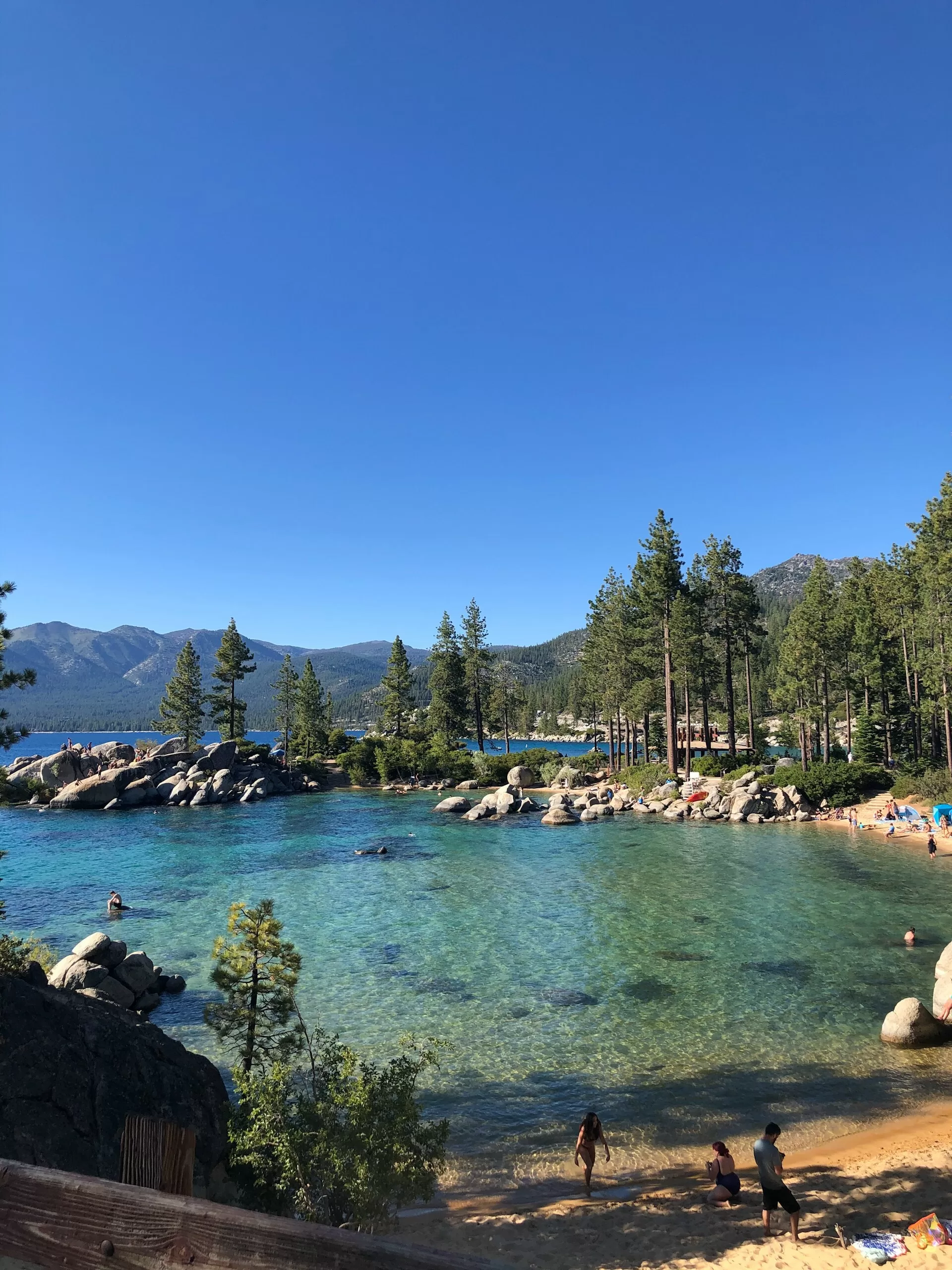 Klein strandje met bezoekers aan het kraakheldere turquoise water van Lake Tahoe
