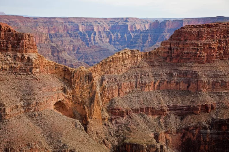 Grand Canyon met duidelijk zicht op de verschillende gekleurde rotslagen en diepe kloven onder blauwe lucht