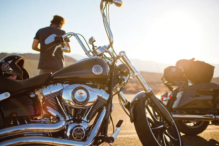 Geparkeerde motoren van Eaglerider met de bestuurder kijkend naar de zonsondergang