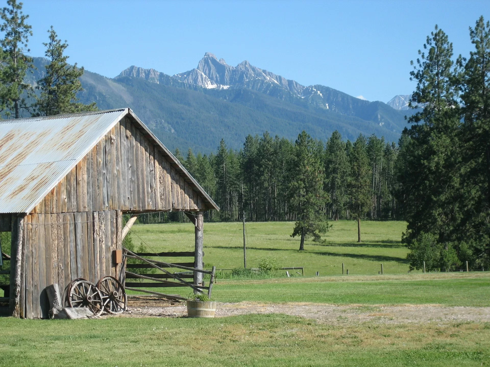Een houten schuurtje met bergen op de achtergrond in Ronan, Montana