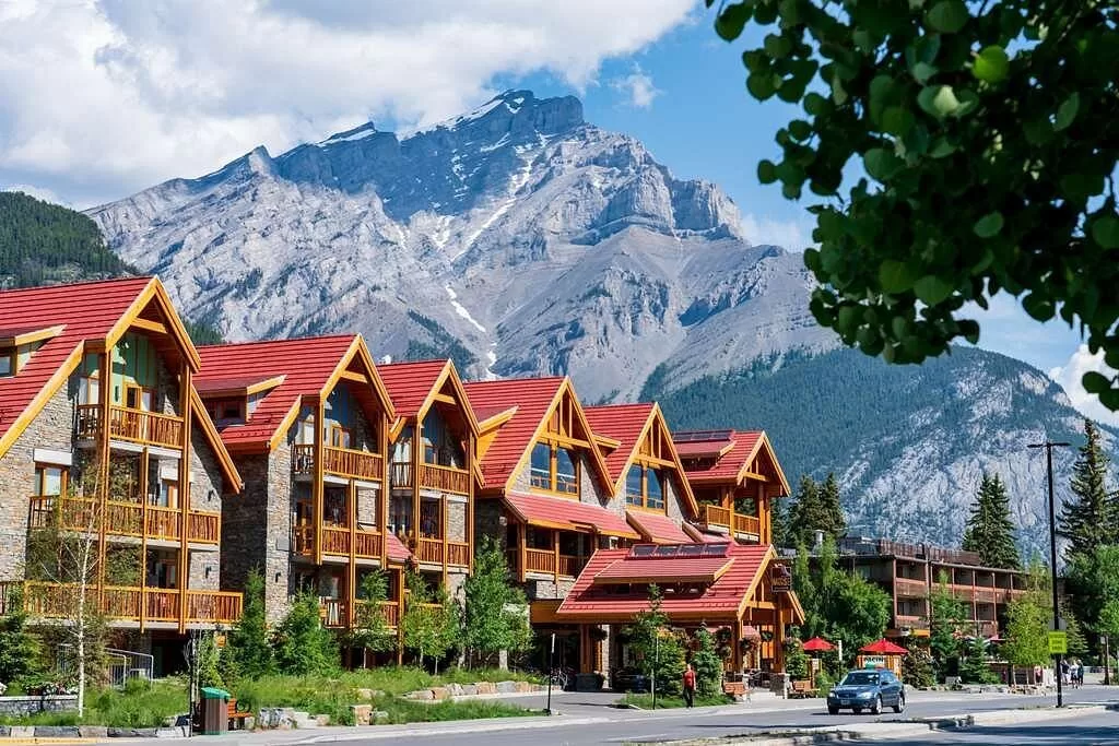 Exterior van het Moose Hotel and Suites Banff met besneeuwde bergen op de achtergrond