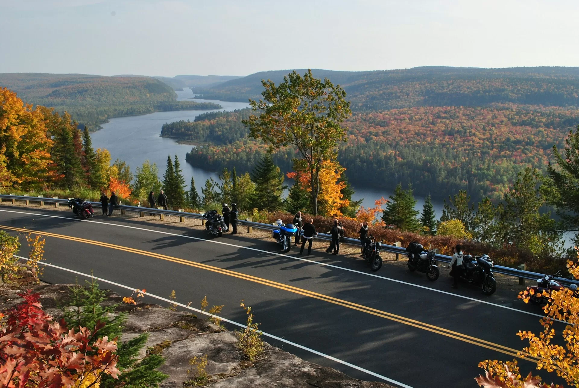Motorrijders die uitkijken over de gekleurde bomen en de rivier van Mauricie National Park in Quebec, Canada