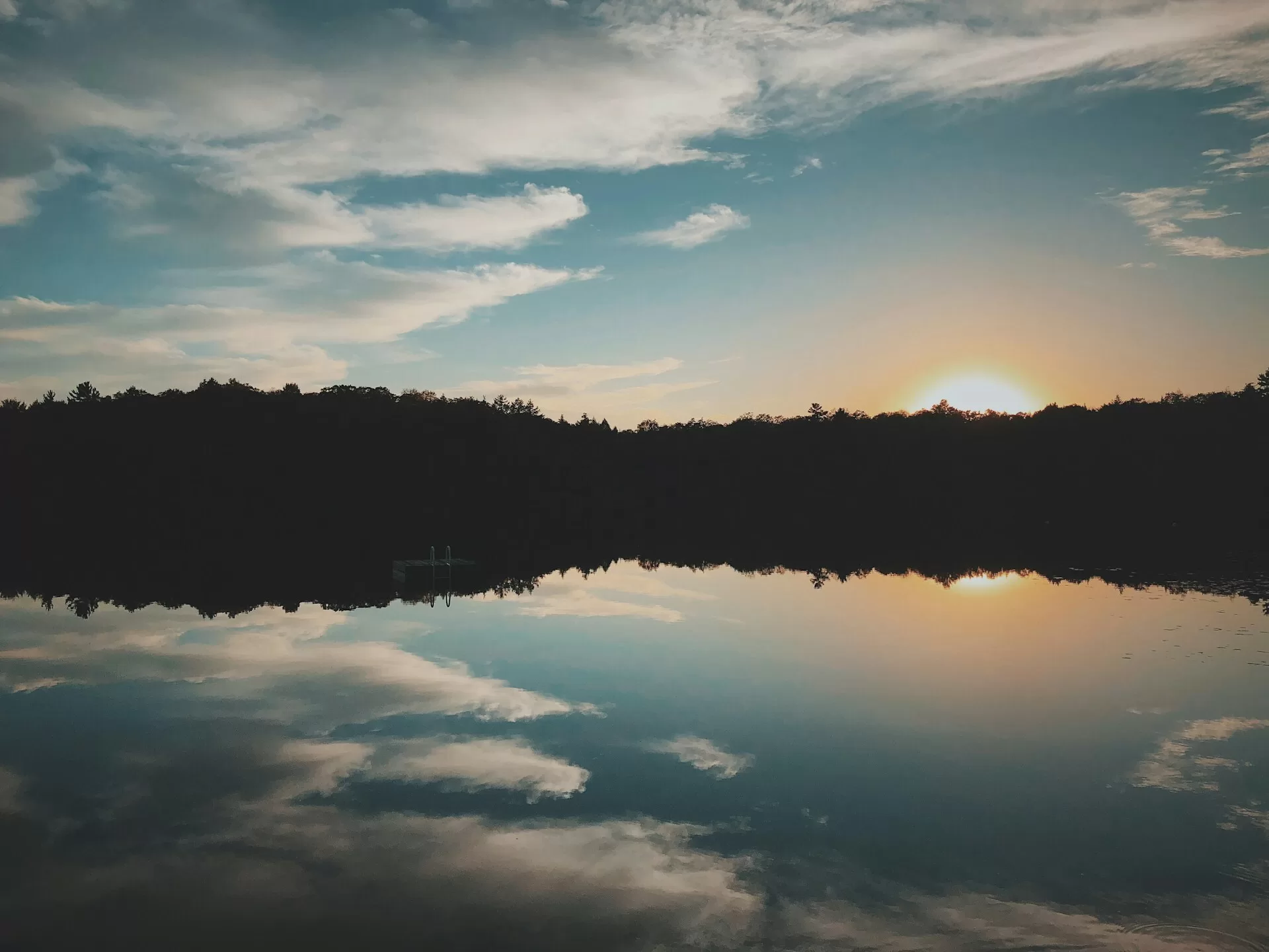 Een meer met een zondondergang op de achtergrond in Parry Sound, Ontario