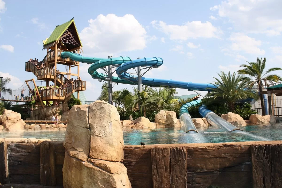 Twee waterglijbanen met een doorzichtige buizen die onder water door lopen in Aquatica waterpark