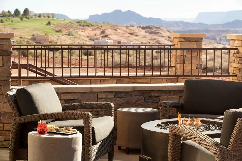Comfortabele stoelen bij een kampvuur op het terras van het Hyatt Place Lake Powell met Lake Powell op de achtergrond