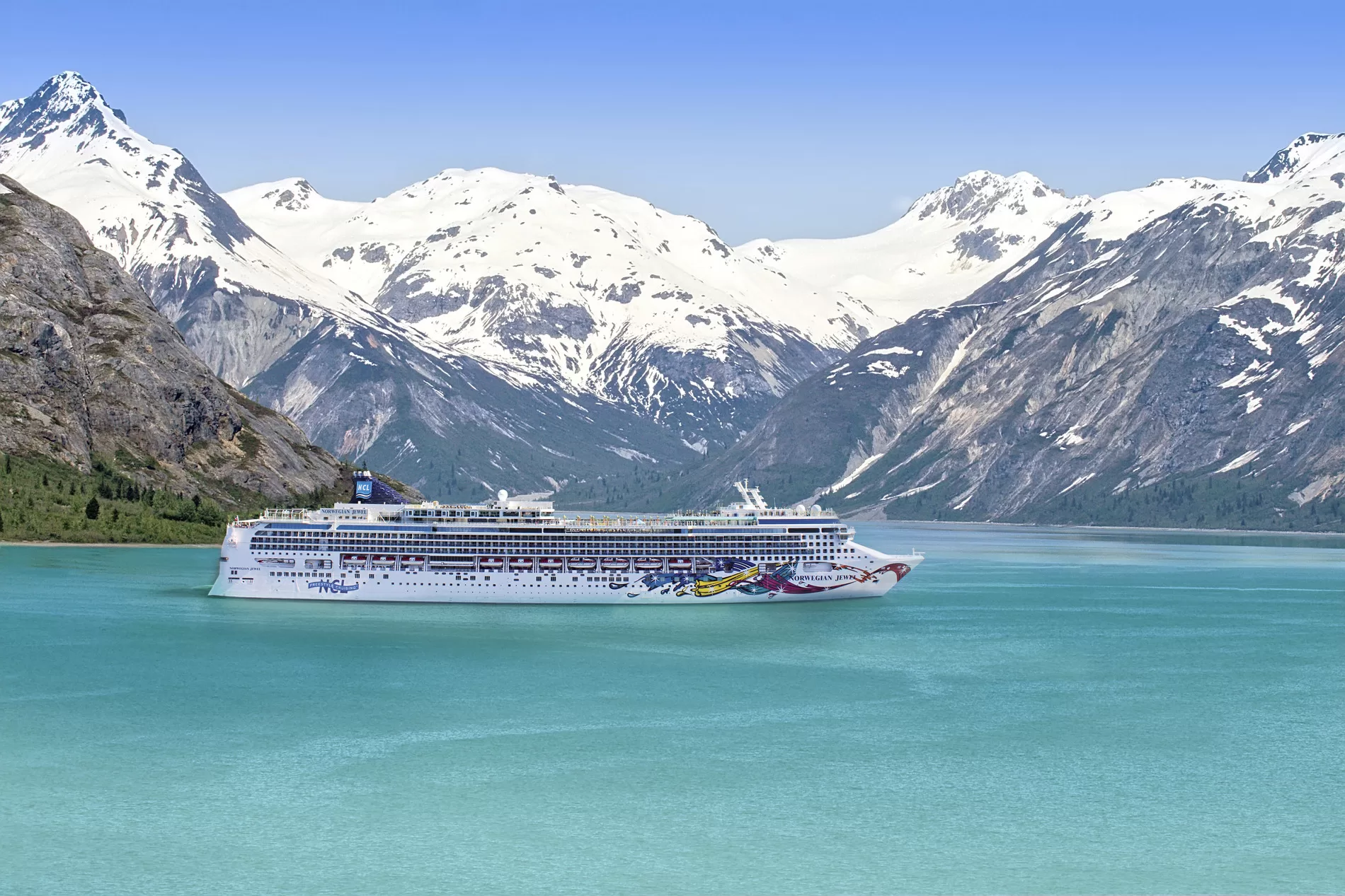 Cruise in Alaska met NCL, omringd door bergen met besneeuwde toppen op de achtergrond