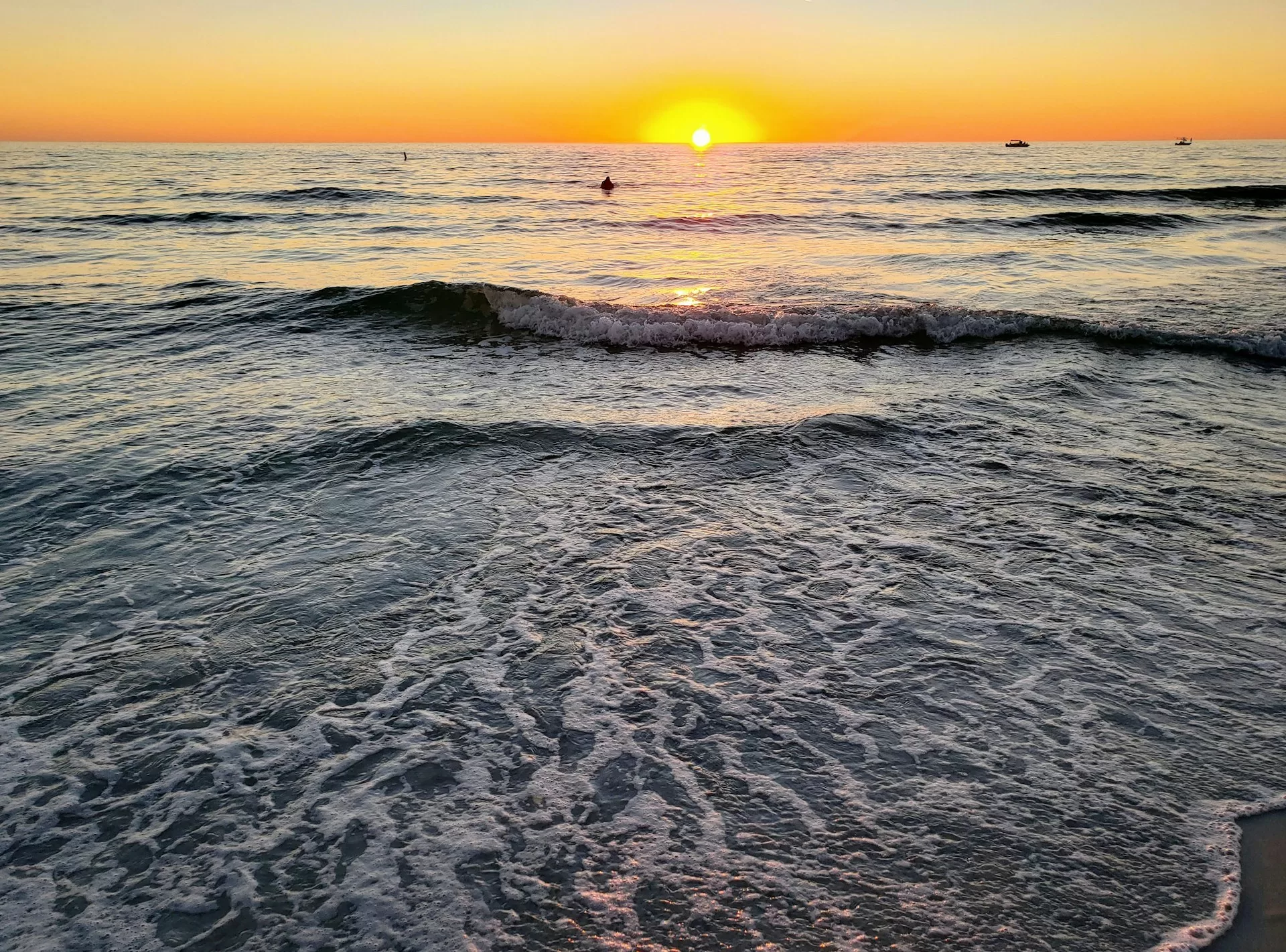 De golven aan St. Pete Beach Florida met ondergaande zon