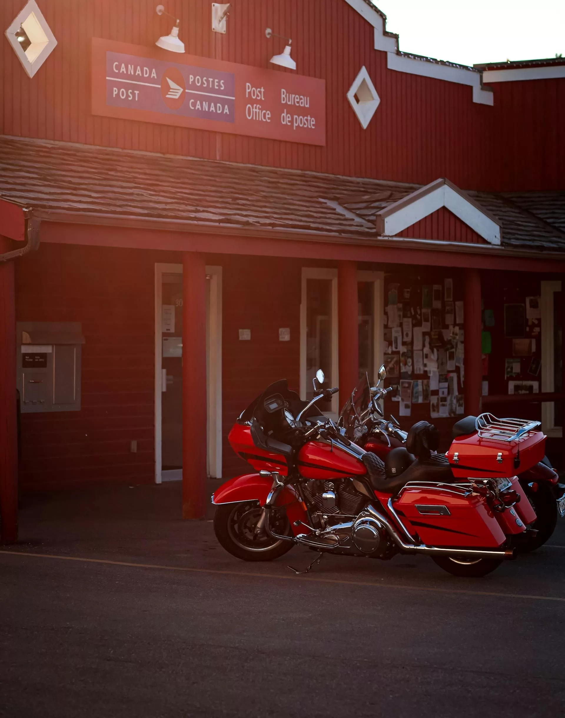 Twee rode motoren geparkeerd bij een postkantoor in Canada