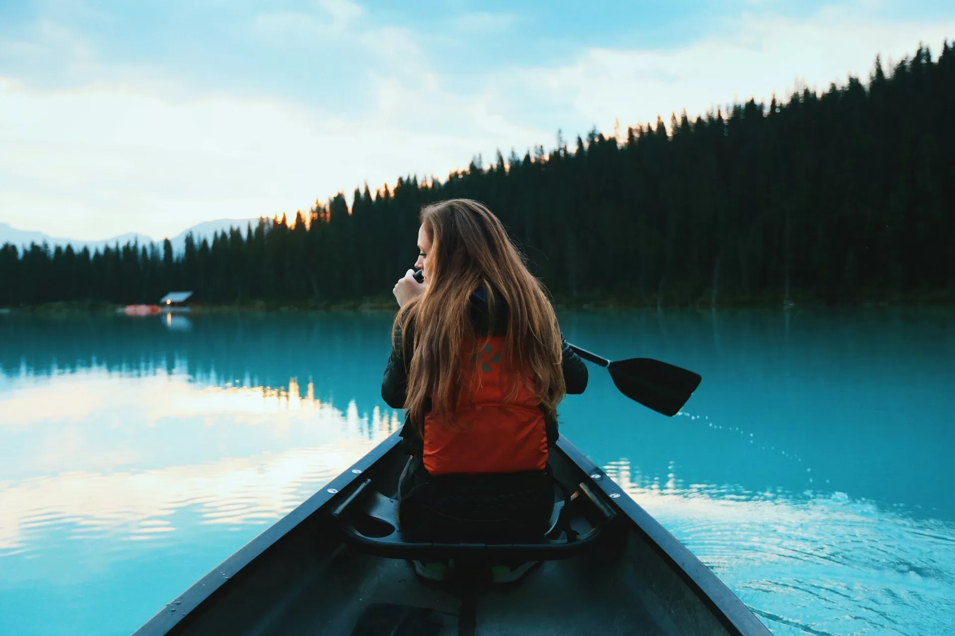 Vrouw in kano op het turquoise water van Lake Louise in Canada
