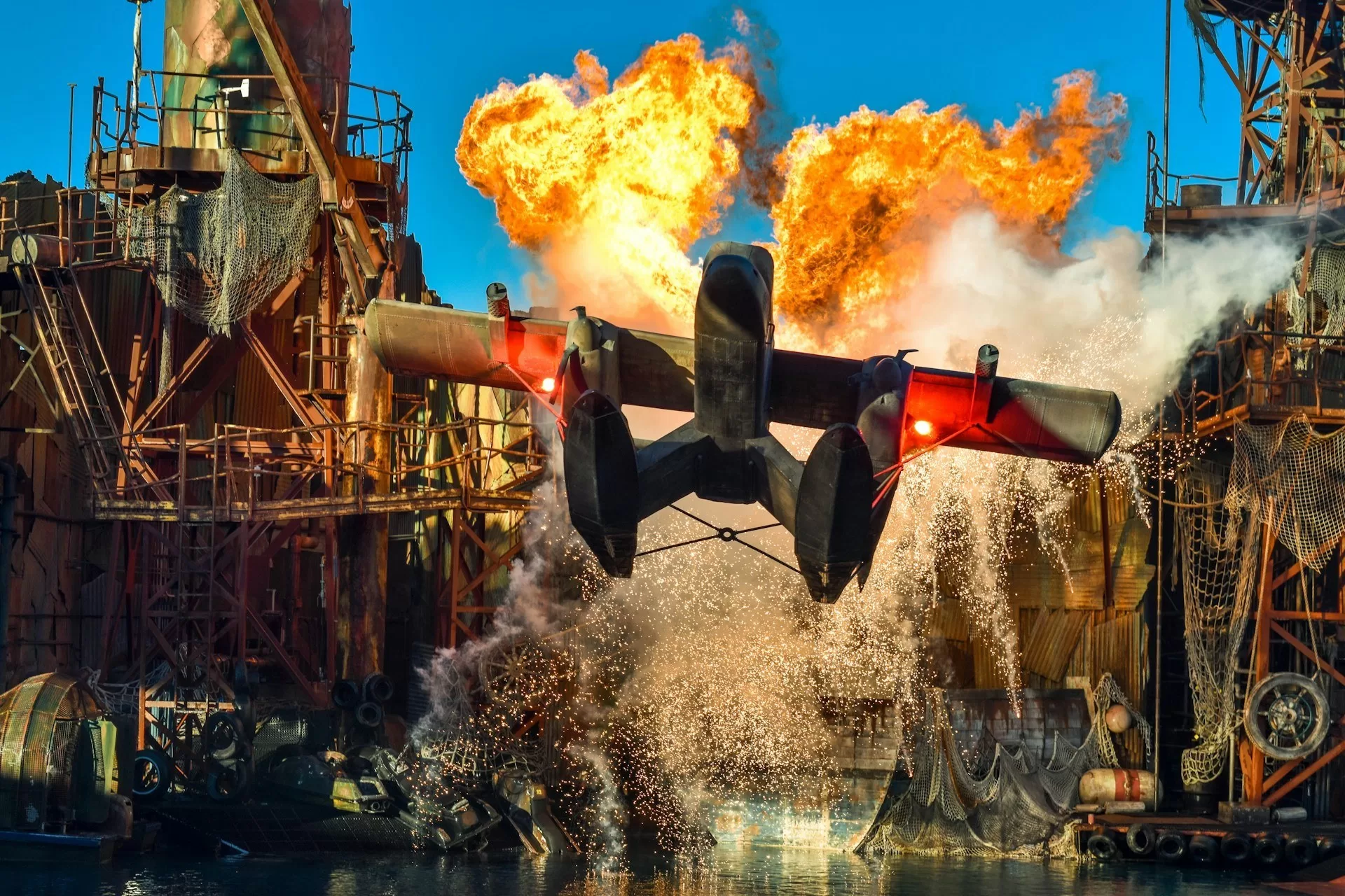 Vliegtuig op de voorgrond tijdens actieshow met vuur en explosies op de achtergrond in Universal Studios