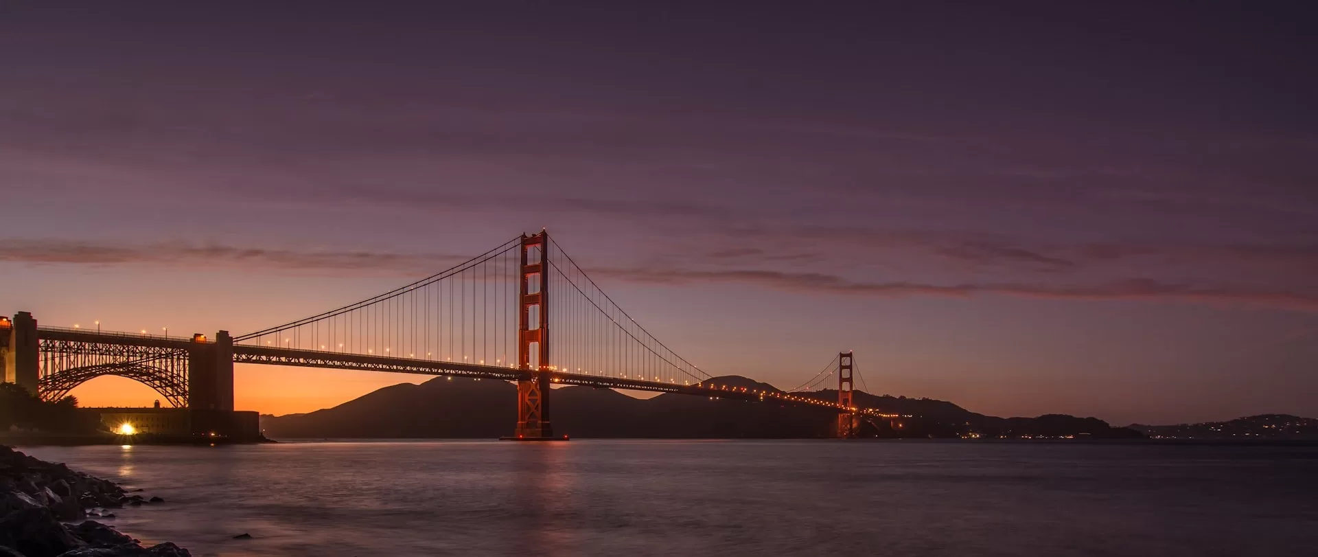 Golden Gate Bridge bij zonsondergang met paarse lucht