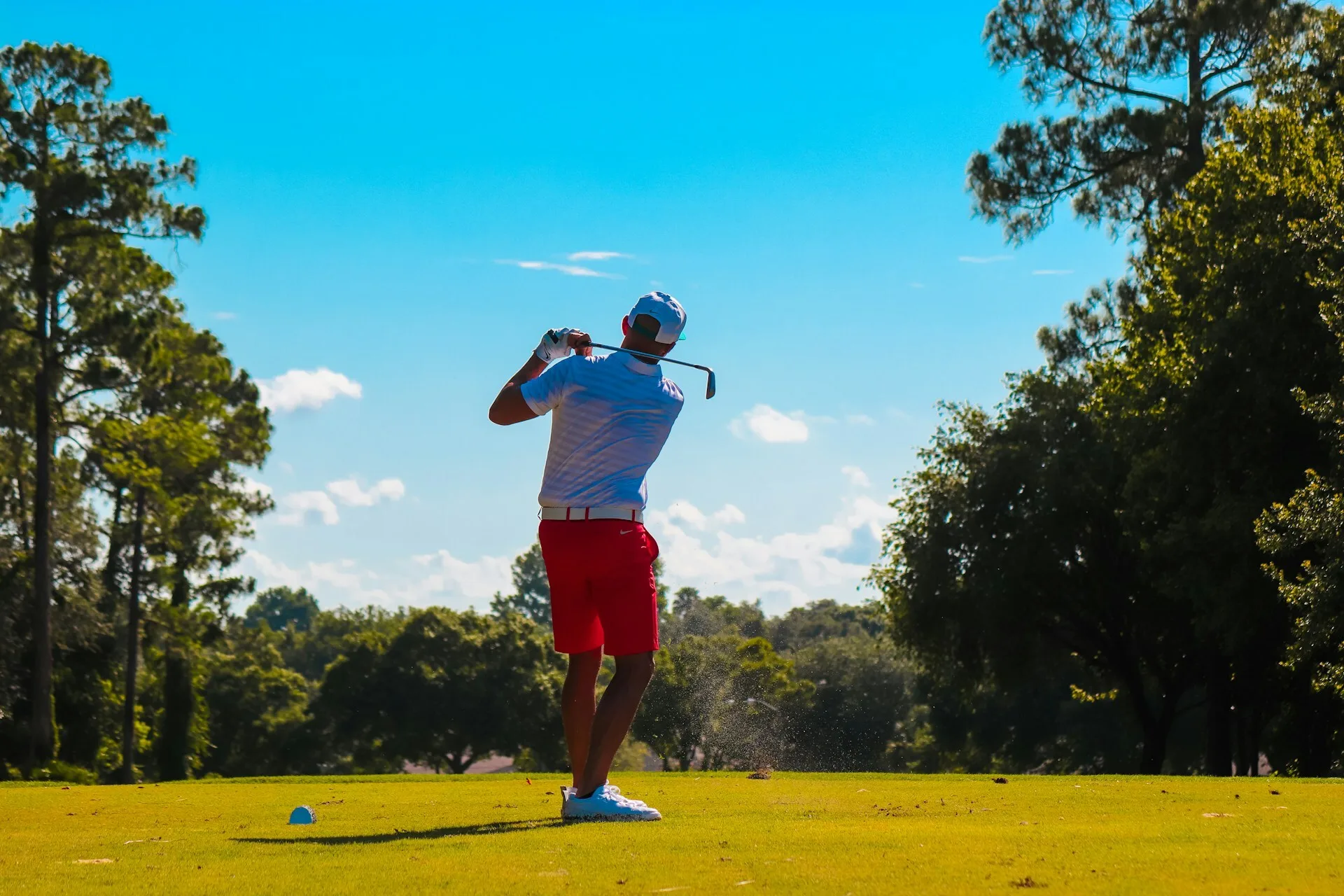 Man speelt golf op een zonnige golfbaan