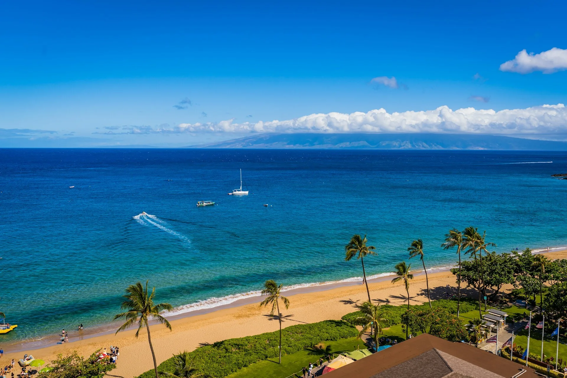 Luchtfoto vanaf land op Kaanapali Beach Maui met kleine bootjes op de Pacific