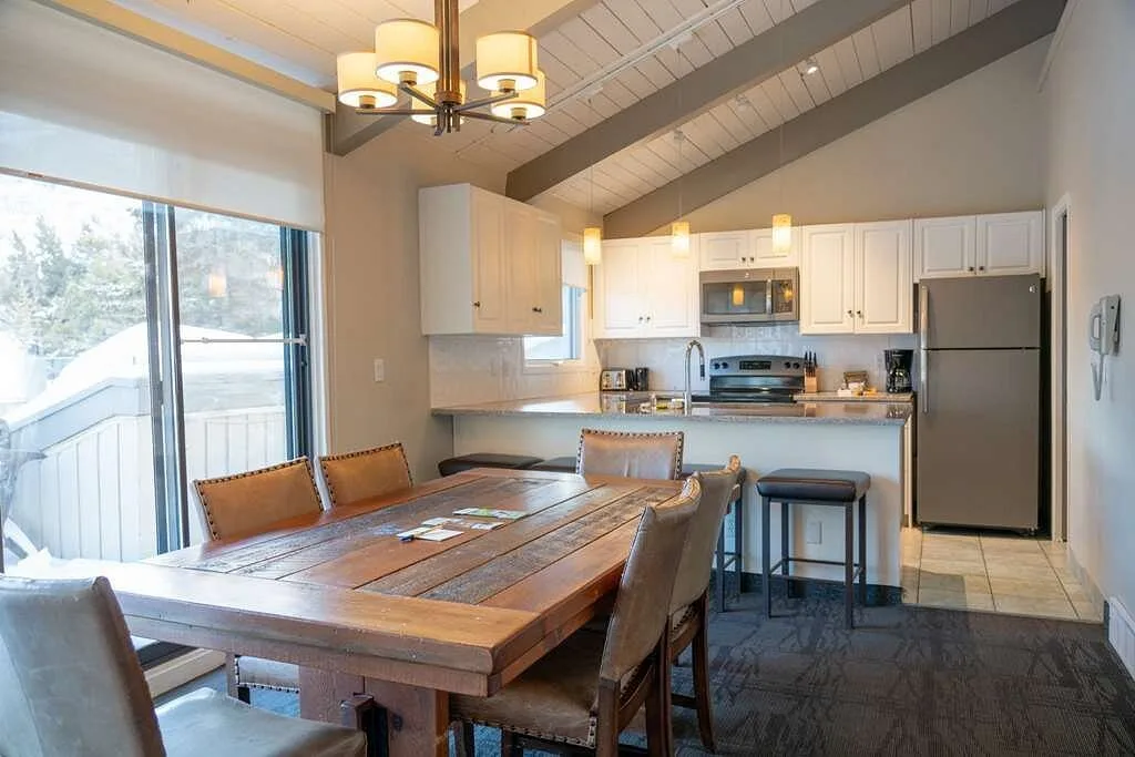 Keuken en eettafel met balkon in een hotelkamer in het Hotel Tunnel Mountain Resort Banff