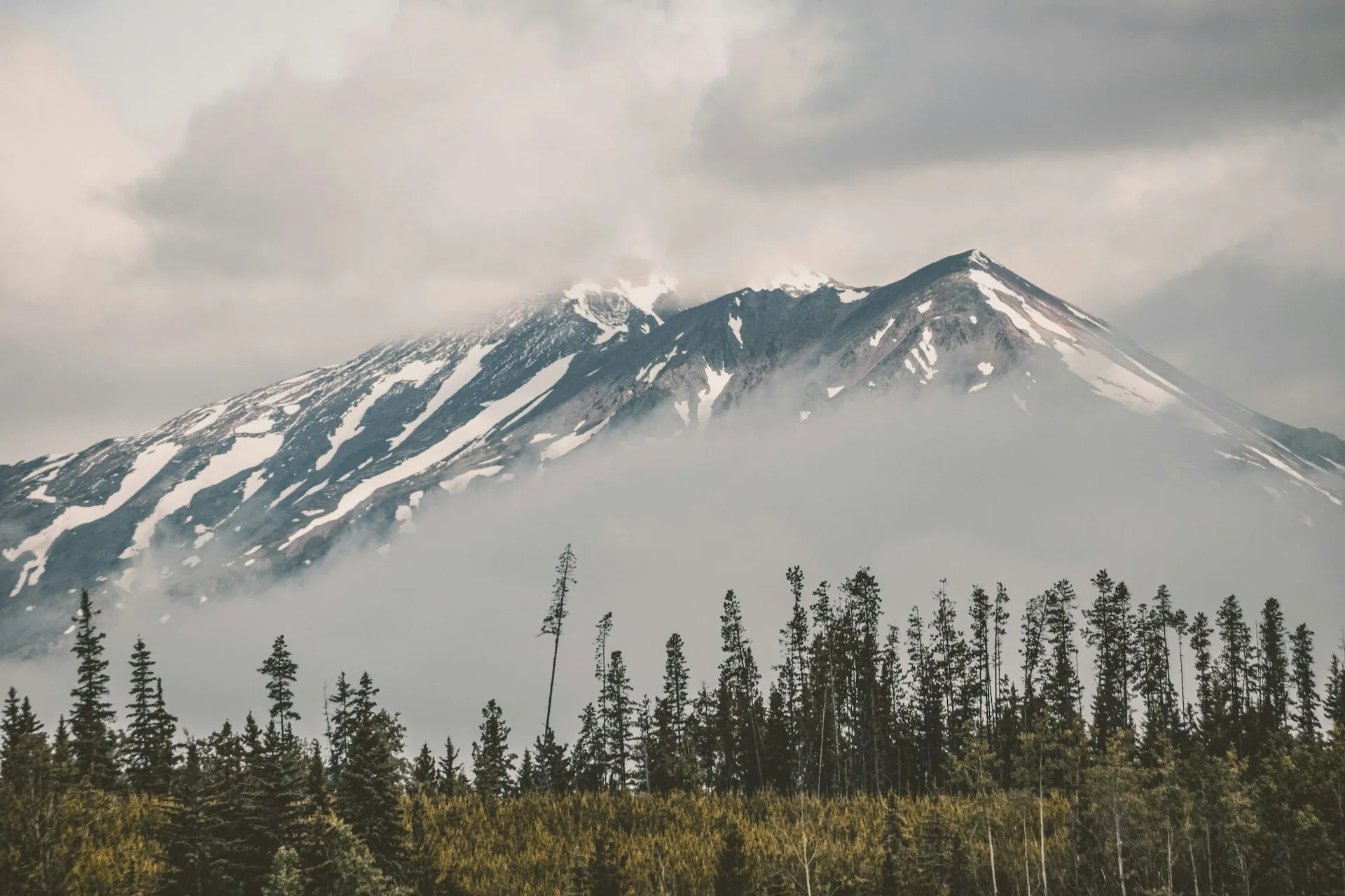 Besneeuwde bergtoppen van Hudson Bay Mountain omringd door wolken in Smithers West Canada