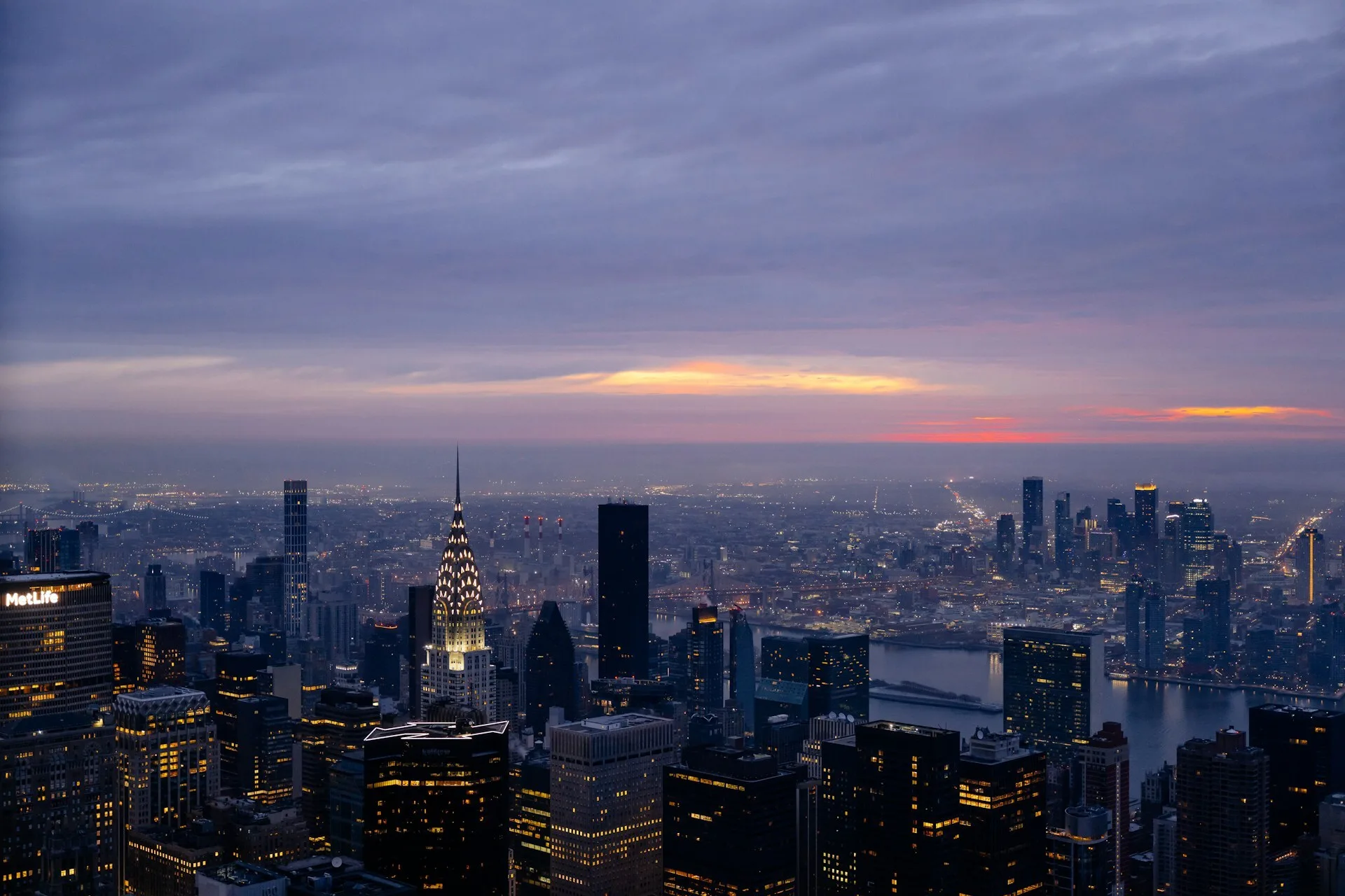 De skyline van New York City bij een bewolkte zonsondergang