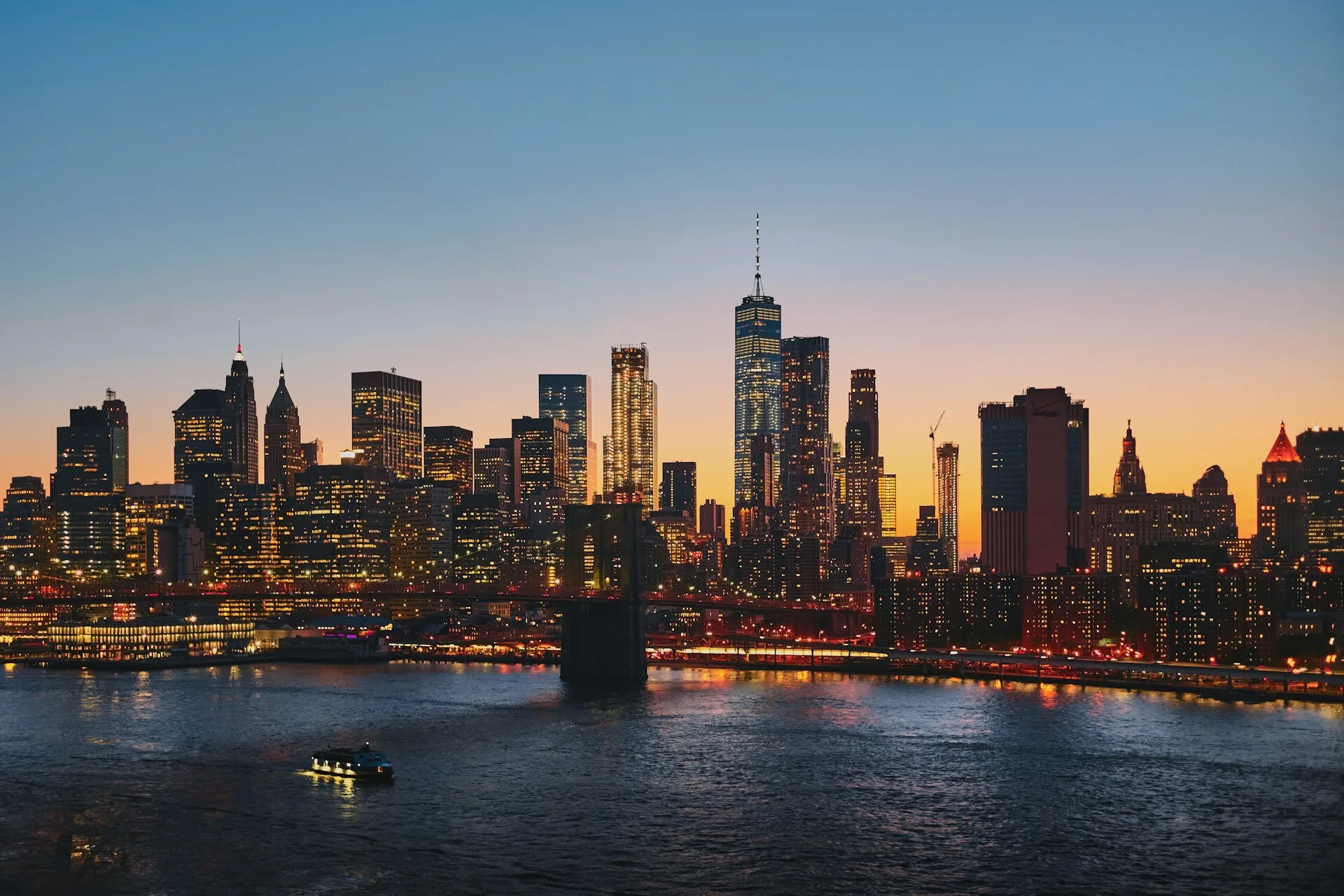 De verlichte skyline van New York City tijdens een zonsondergang