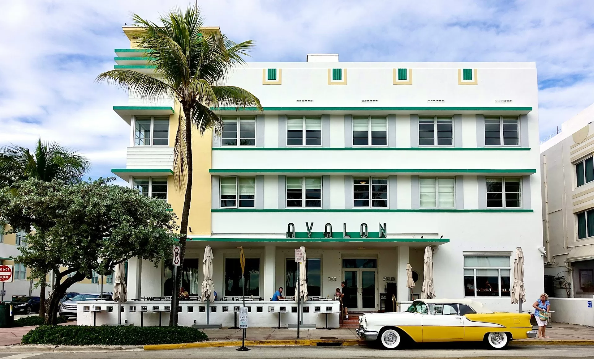 Avalon Hotel in Miami op een bewolkte dag met geel-witte vintage auto geparkeerd ervoor aan Ocean Drive