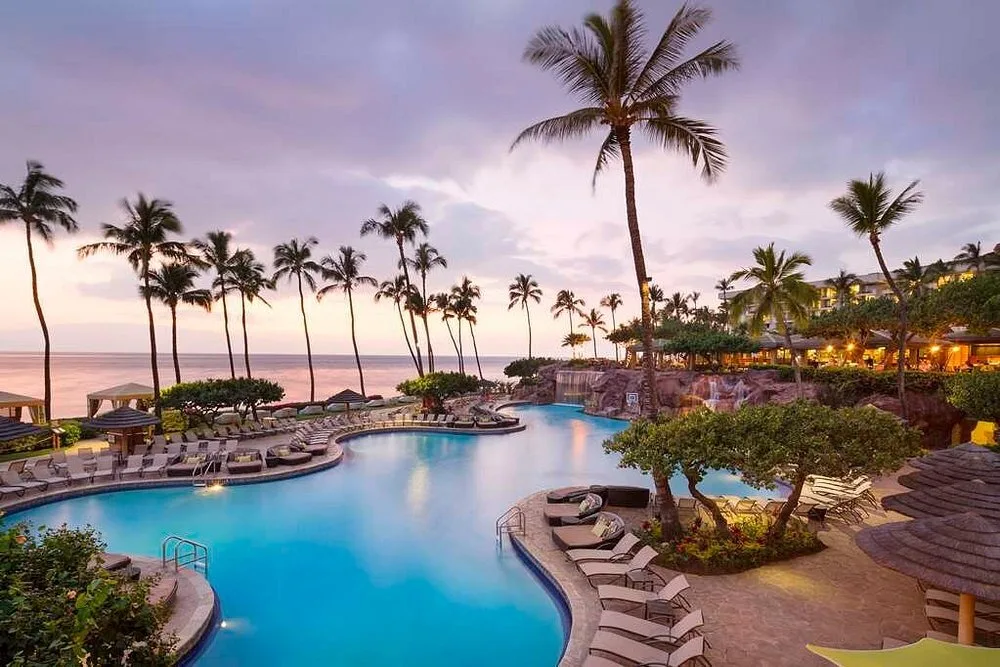 Buitenzwembad met ligbedjes bij het Hotel Hyatt Regency Maui Resort Spa Lahaina met de zee op de achtergrond