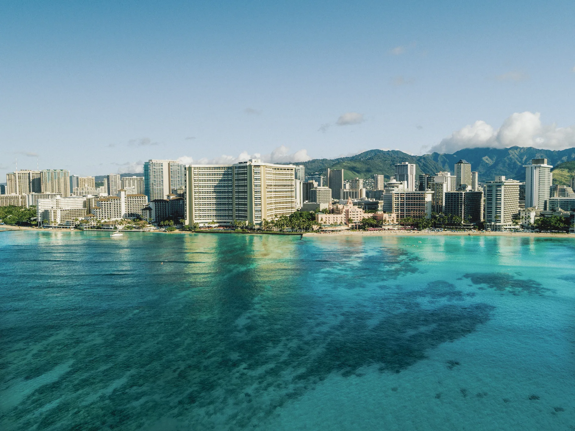 De kustlijn van Waikiki Beach met de turquoise Pacific Ocean op de voorgrond