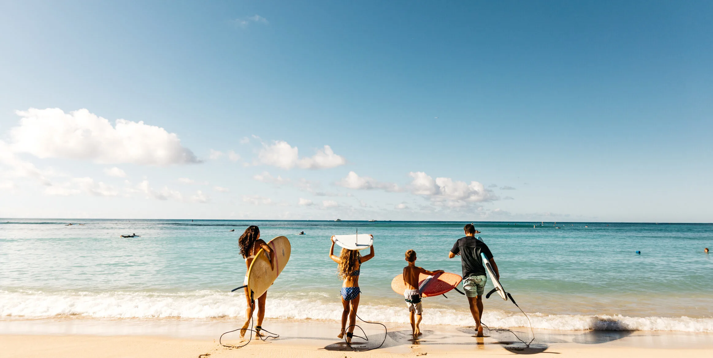 Een familie die gaat surfen in Hawaii
