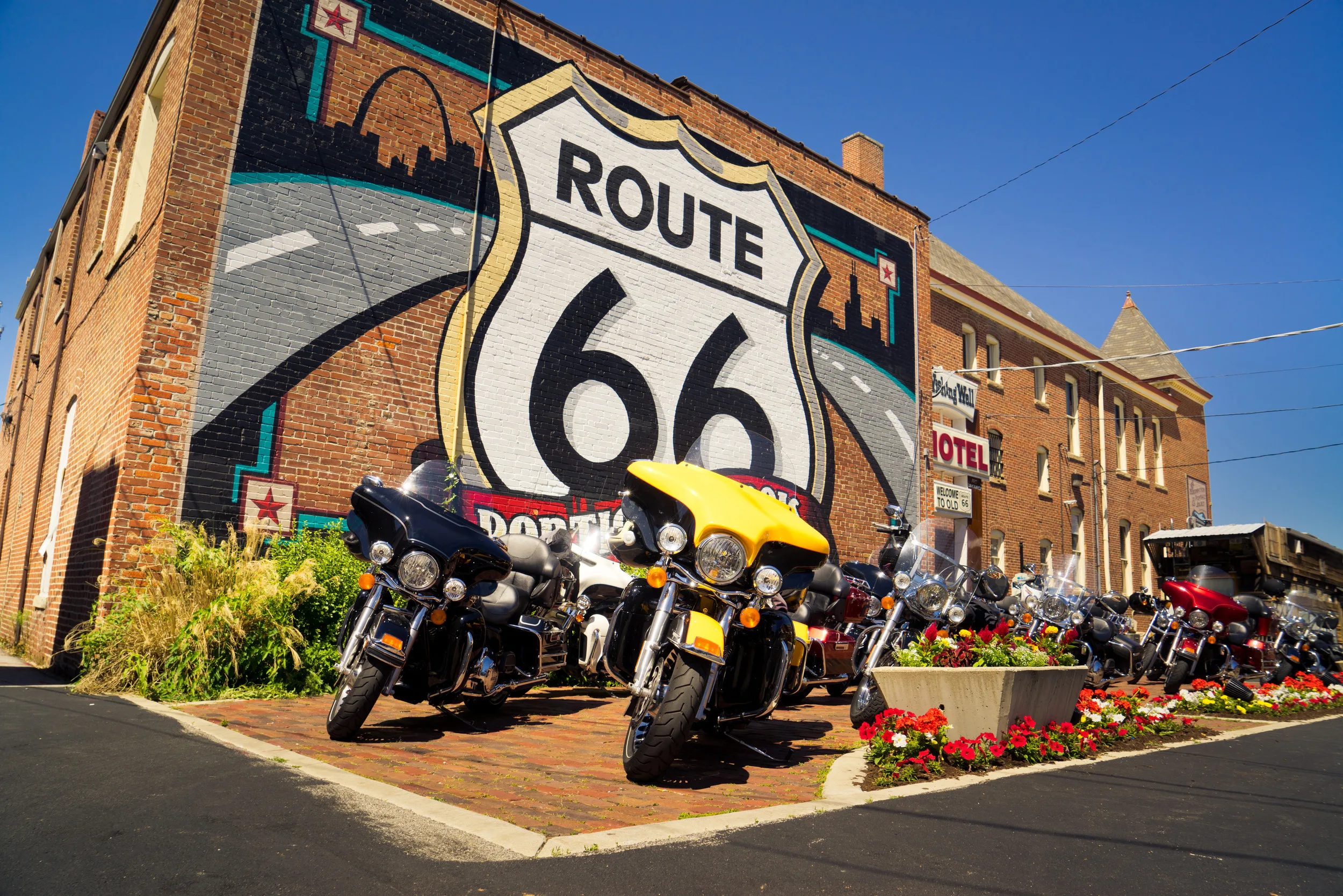 Hotel met groot beschilderd Route 66 sign aan de gevel en geparkeerde motoren voor de deur