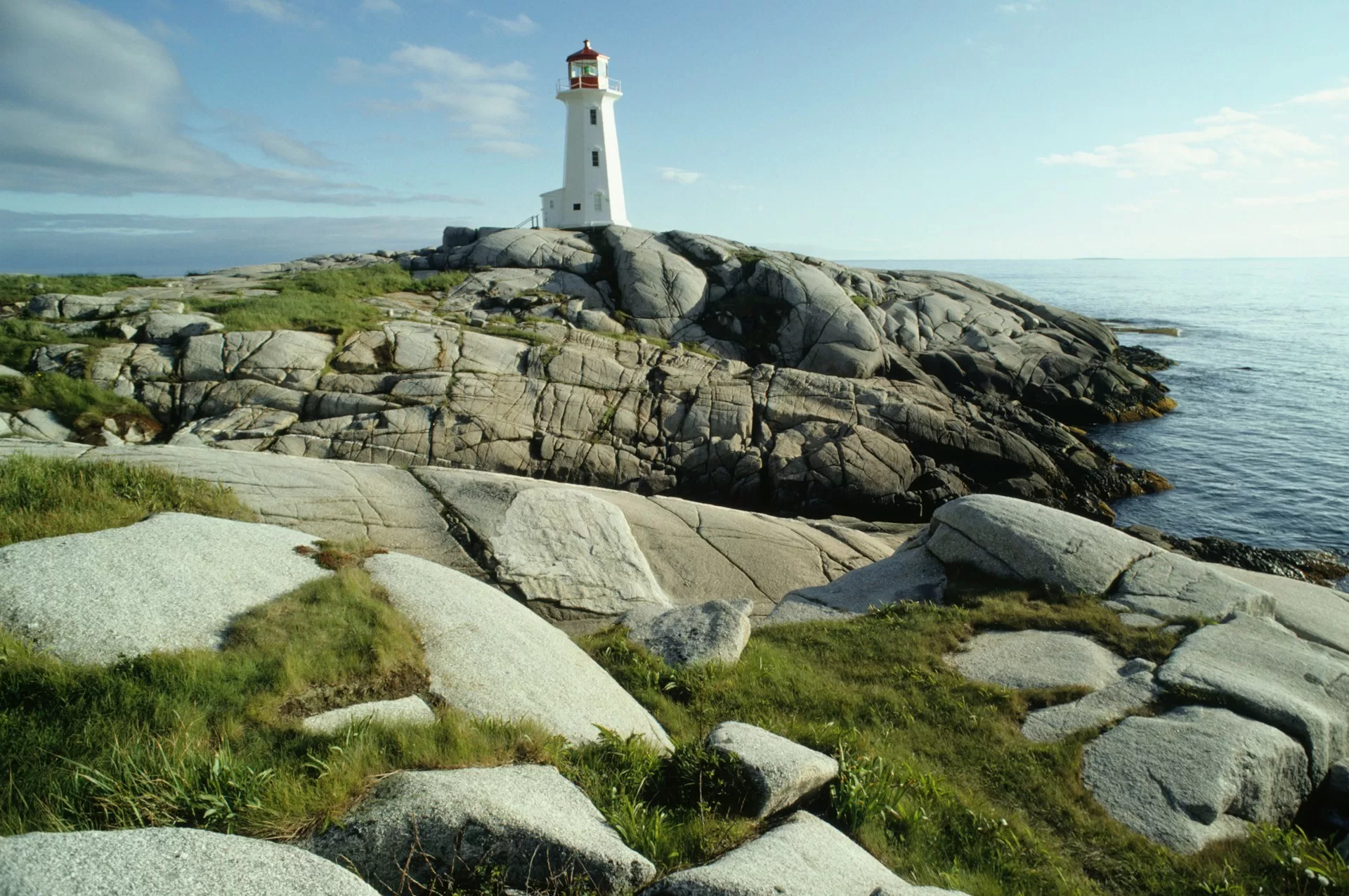 De witte vuurtoren van Peggy's Cove op de rotsachtige kust in Nova Scotia