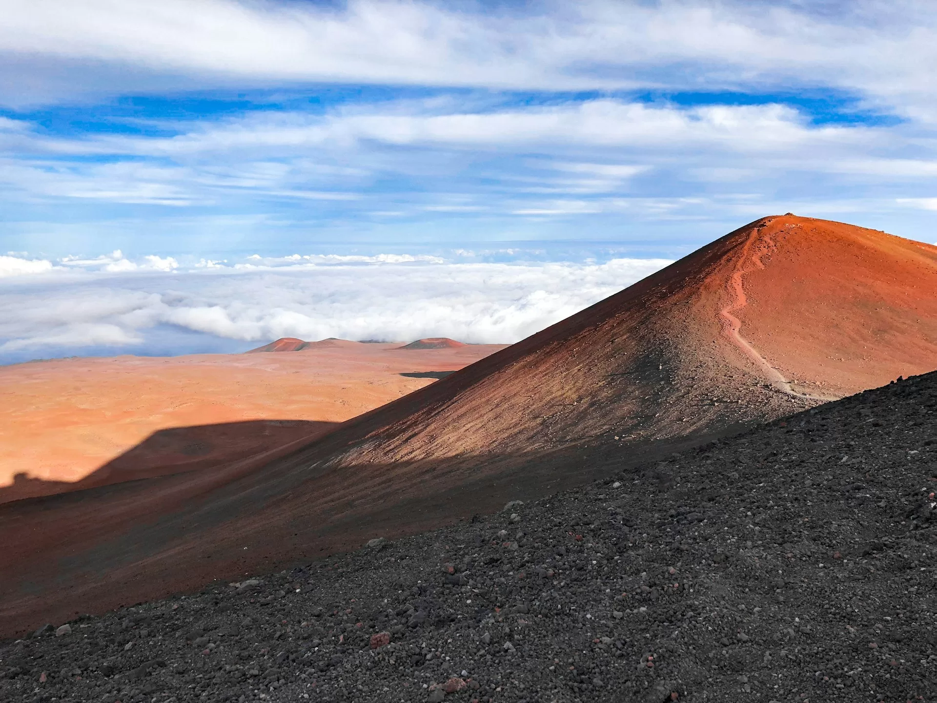 Mauna Kea op Hawaii met wolken op de achtergrond, majestueuze berglandschap