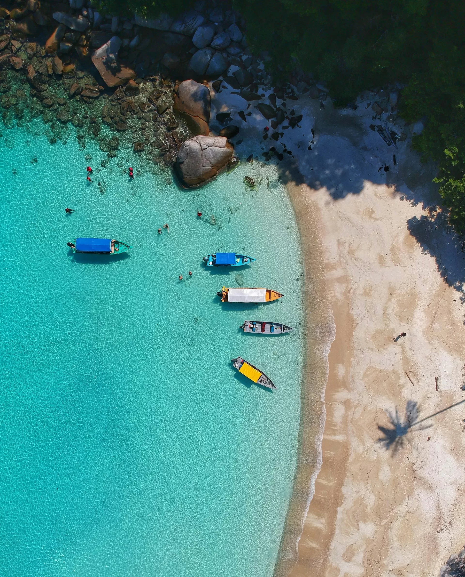Luchtfoto van Niʻihau, Hawaï, met strand en enkele boten in het heldere water