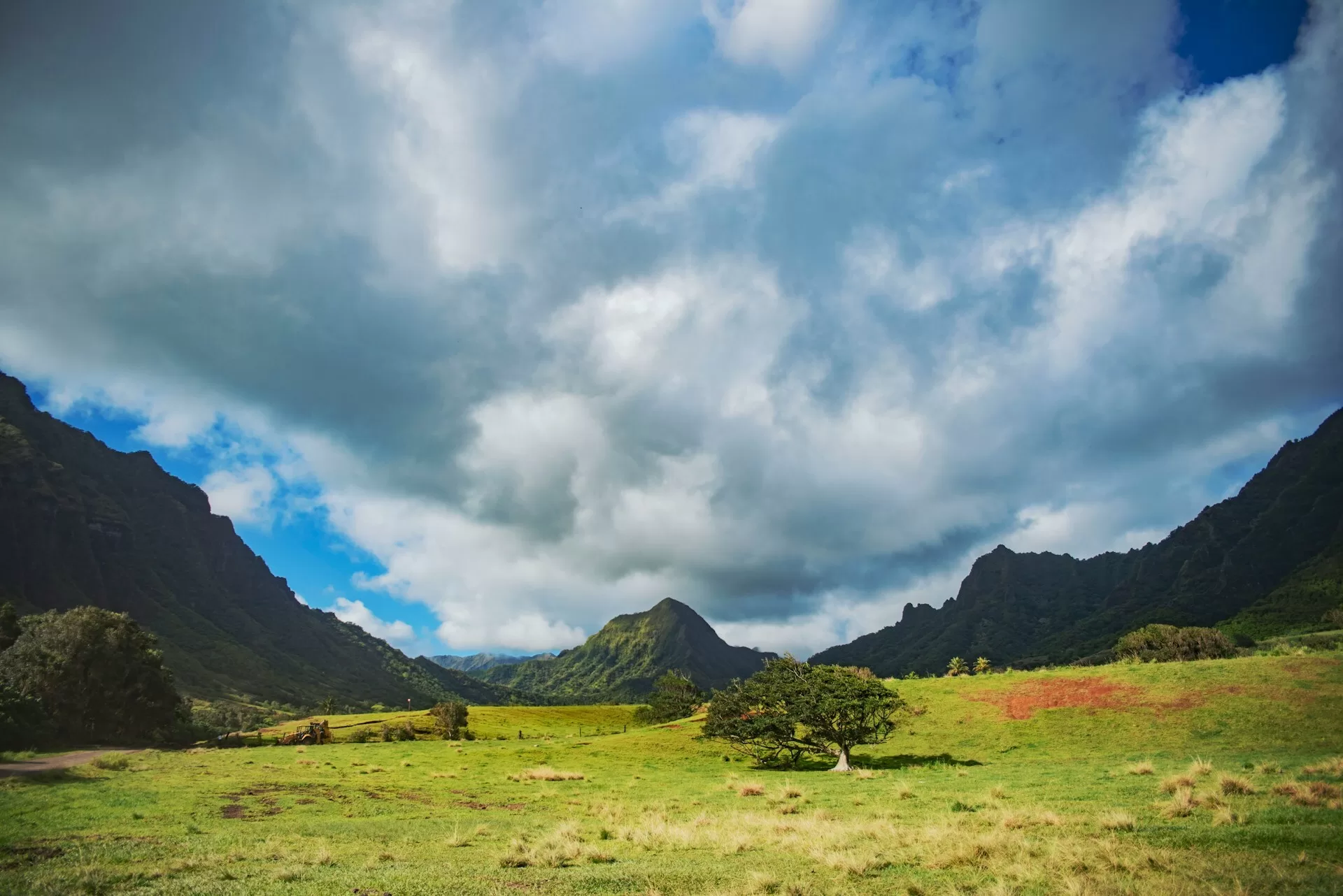 Groen landschap op een bewolkte dag met rotsen in de verte, natuurlijke landschap in Hawaii