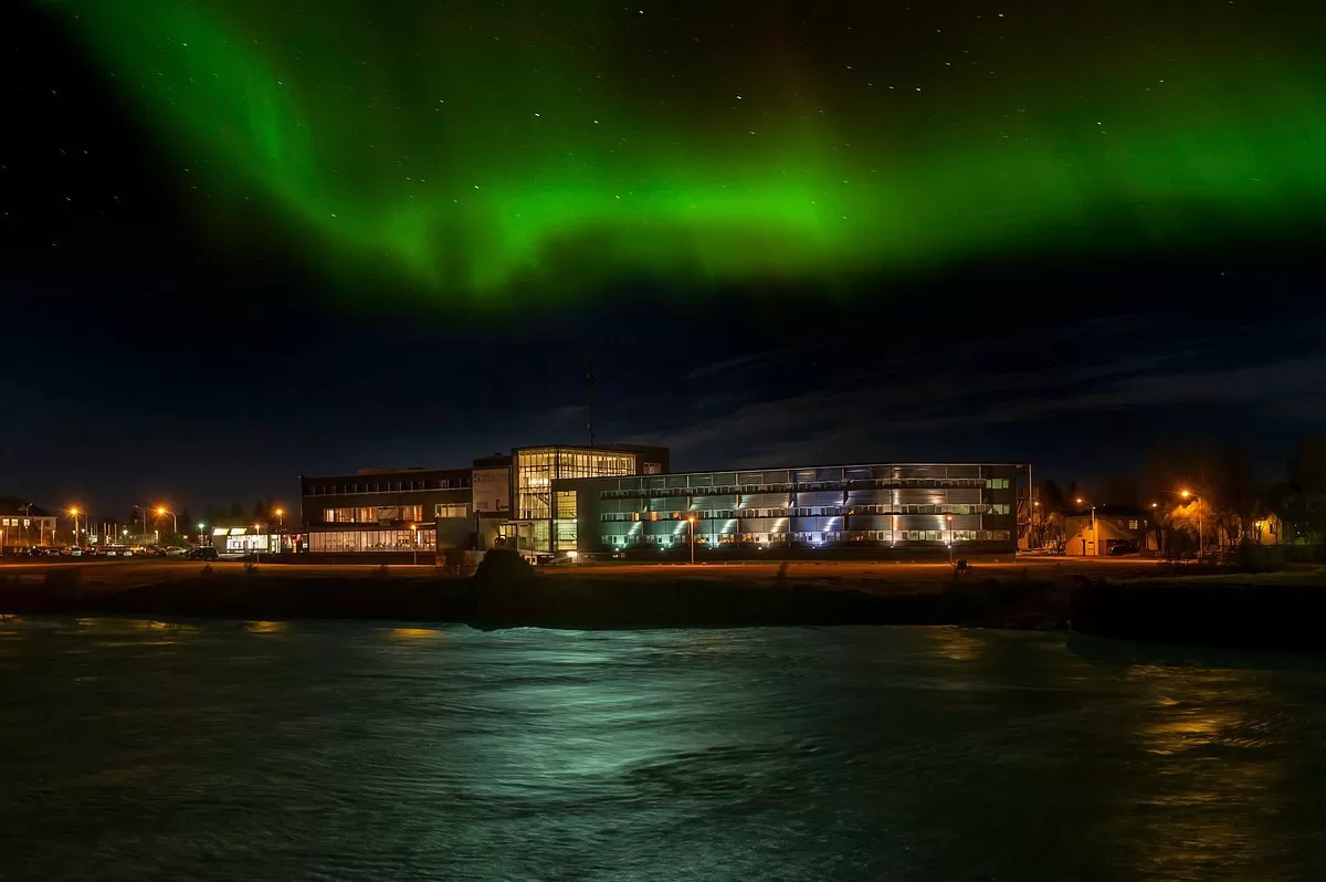 Exterior van het Hotel Selfoss aan het water met het Noorderlicht erboven
