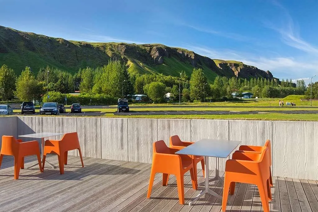 Terras met uitzicht over de groene bergen bij het Hotel Klaustur