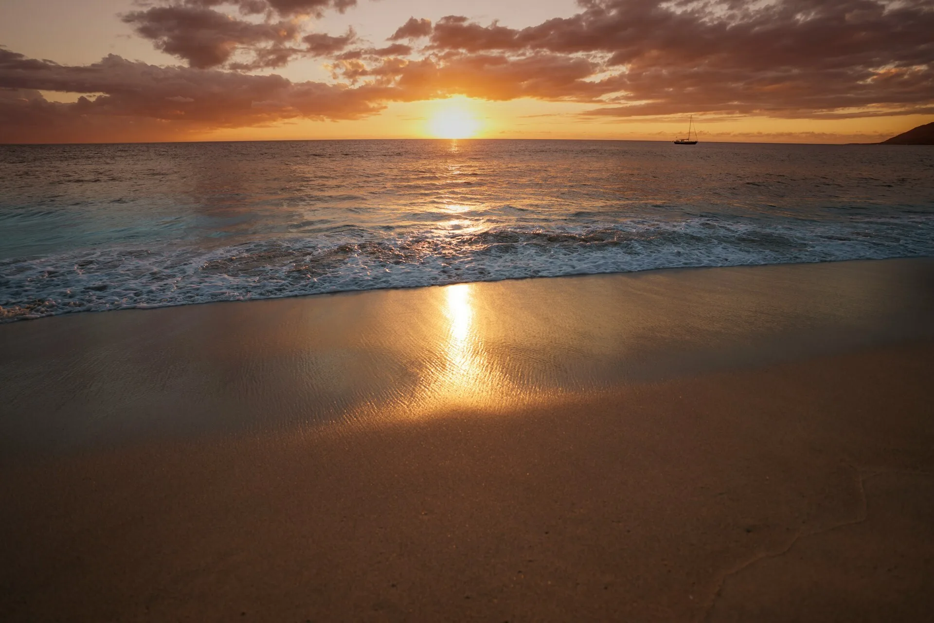 Zonsondergang op strand met schuimende golven