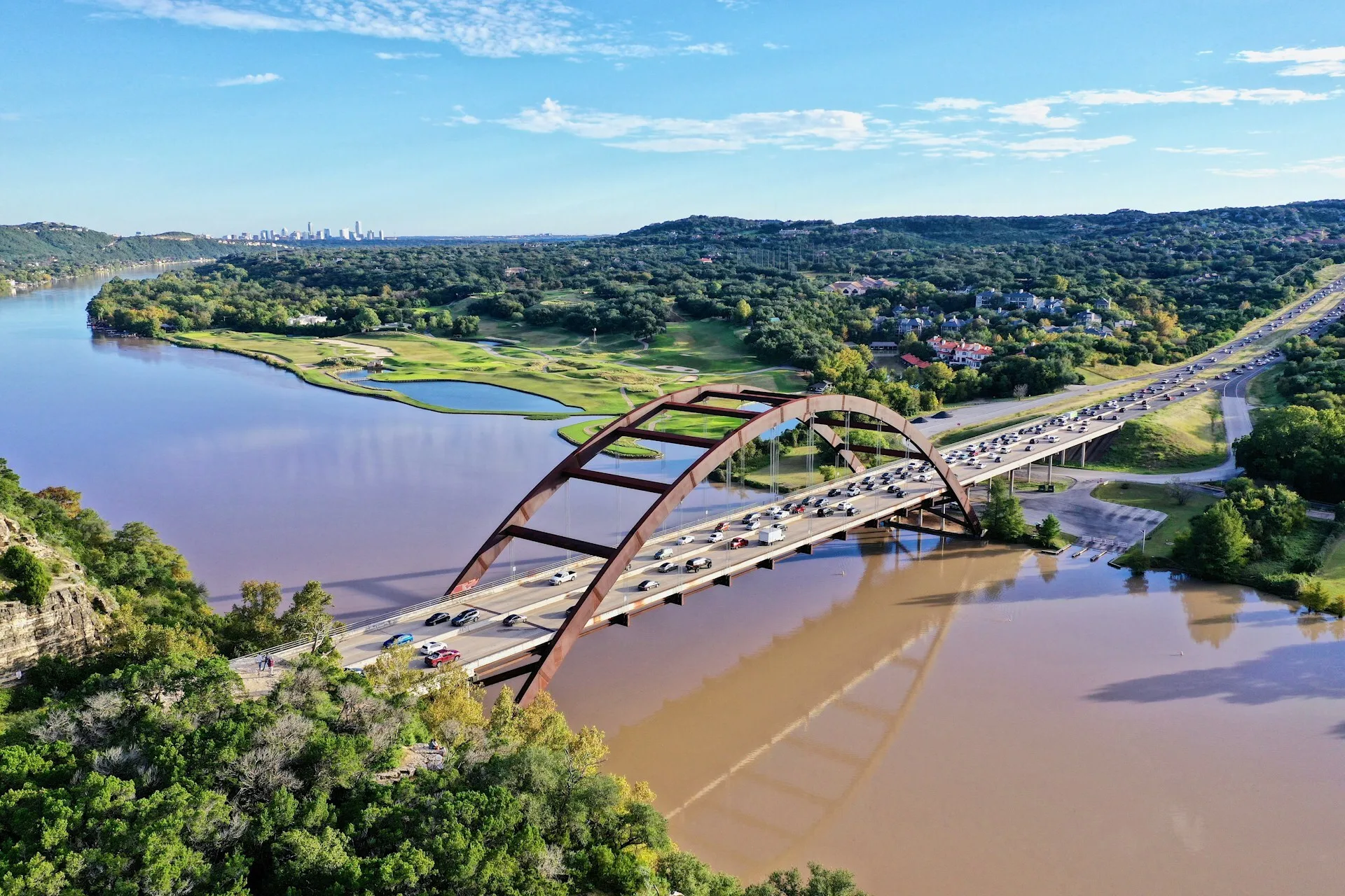 De Pennybacker Bridge over een bruingekleurde Colorado River in Austin, Texas