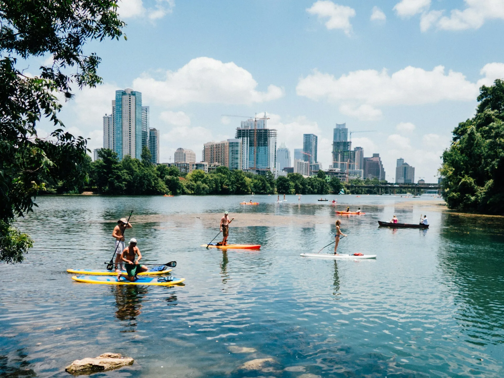 Mensen die paddleboarden en kajakken bij Lou Neff Point met de skyline van Austin op de achtergrond