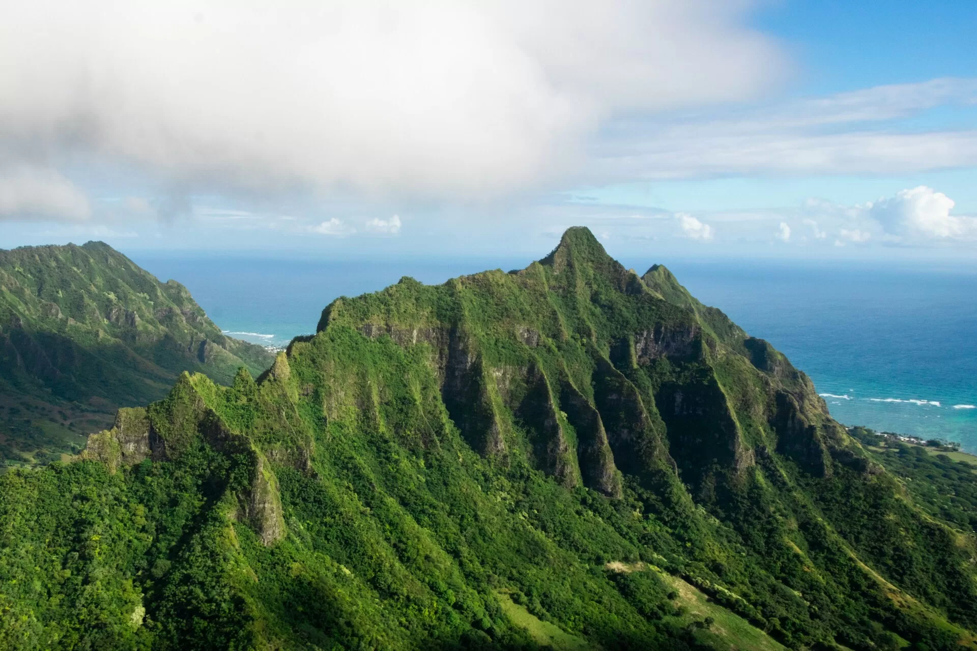 Kualoa Ranch op Oahu, Hawaii, met weelderig groen en de oceaan op de achtergrond