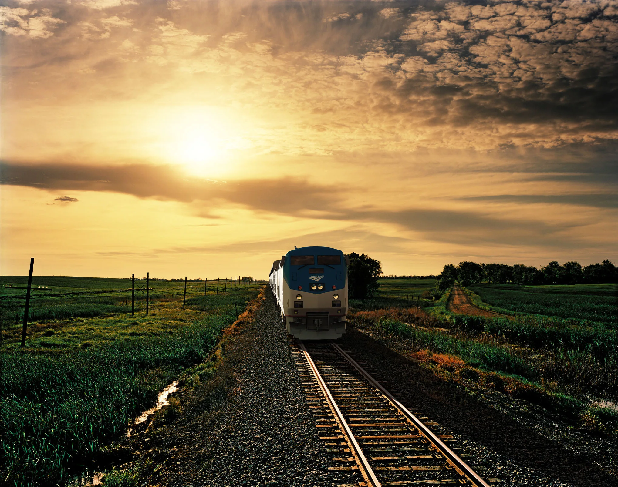 Amtrak trein tussen de steden aan de Oostkust van de USA met goudgekleurde lucht op de achtergrond