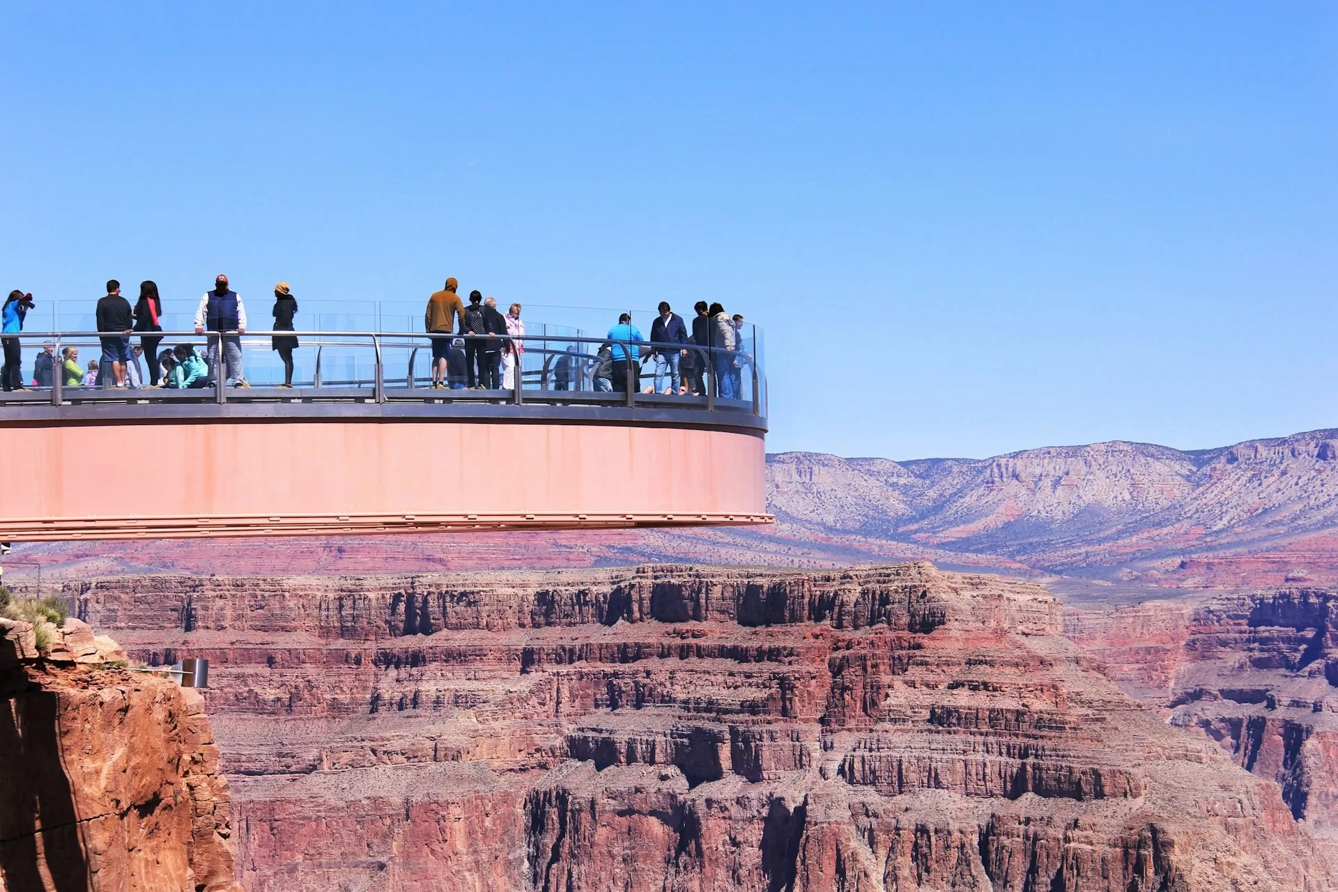 Mensen staan op de Grand Canyon Skywalk, uitkijkend over de diepe kloof en indrukwekkende rotsformaties
