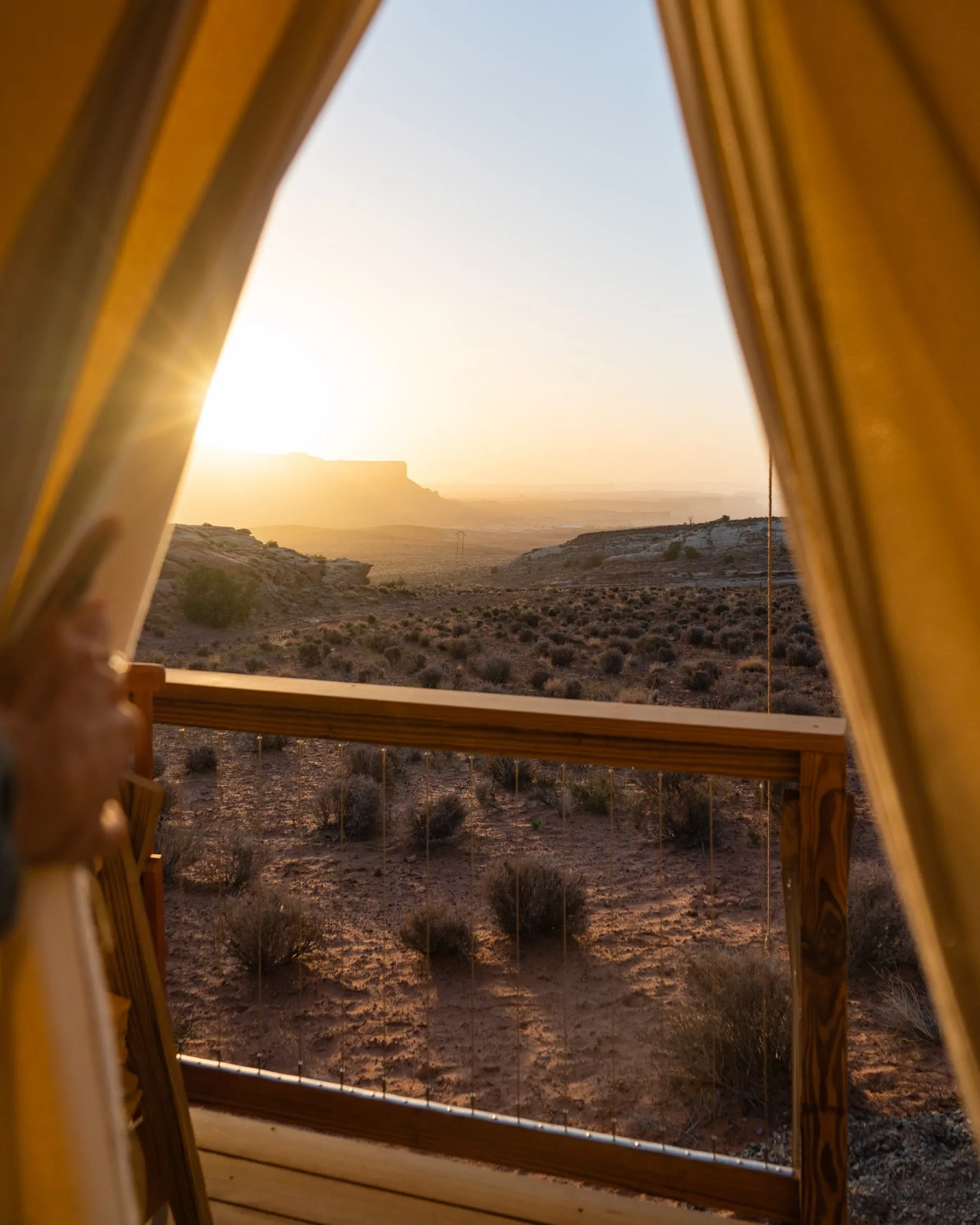 Uitzicht vanuit een Glamping tent op een zonsondergang achter de red rocks in Lake Powell West Amerika