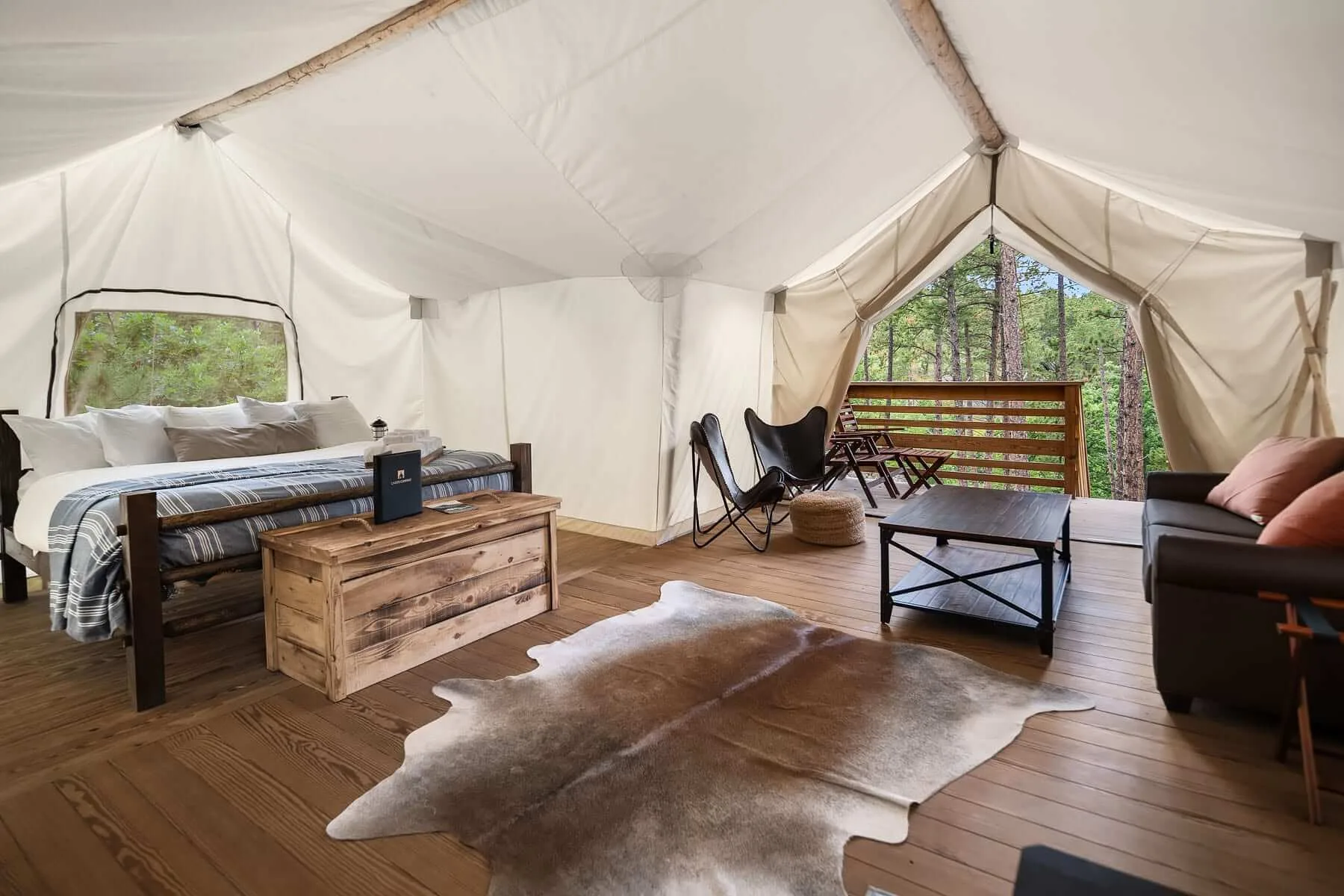 Binnenzijde witte glamping tent met bed en zithoek in Yosemite National Park