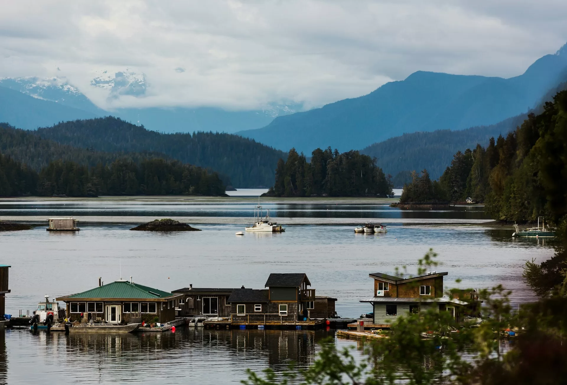 Drijvende huizen en boten aan de kust van Vancouver Island, omringd door bergen, eilanden en dennenbossen in Canada