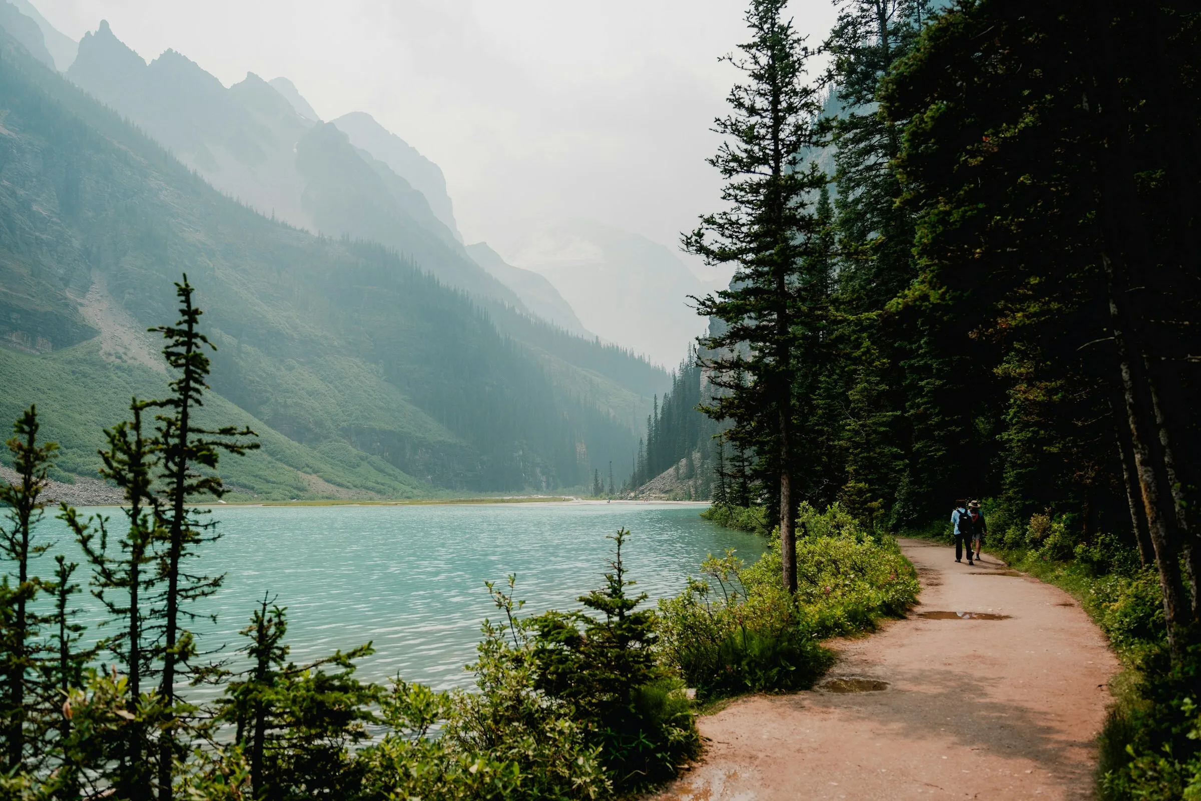Een wandelpad langs een meer met bergen op de achtergrond in Banff National Park in Canada