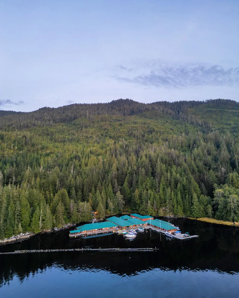 Luchtfoto van het Knight Inlet Lodge midden tussen de bossen en een meer