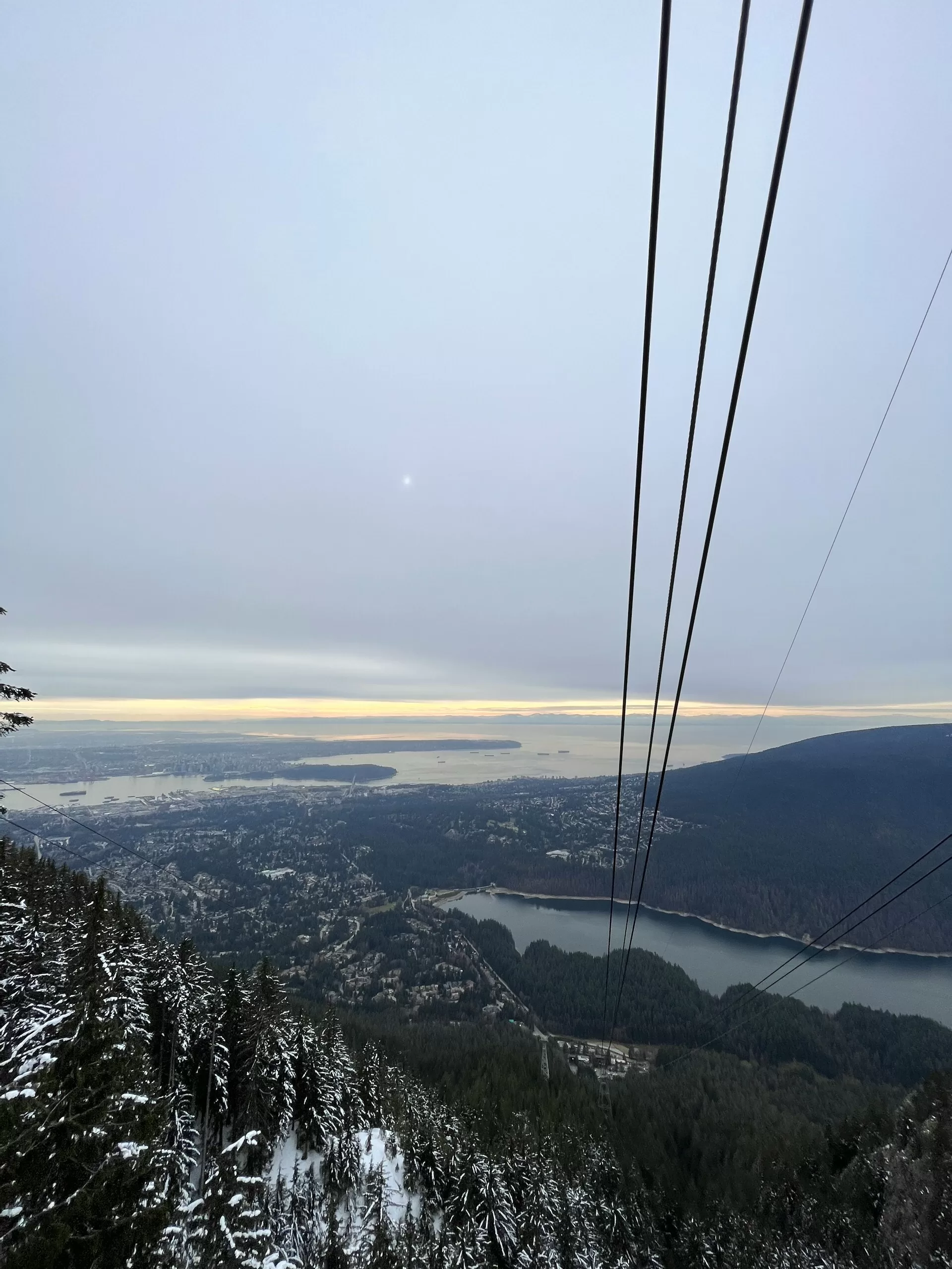 Grouse Mountain kabelbaanrails met uitzicht op water en de stad Vancouver in de verte.